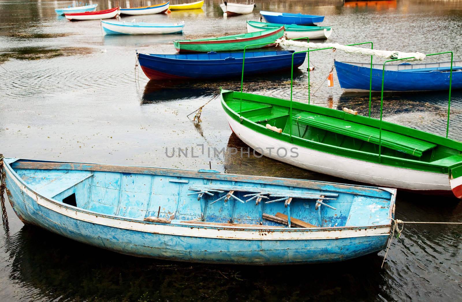 bunch of old boats in calm water by vilevi