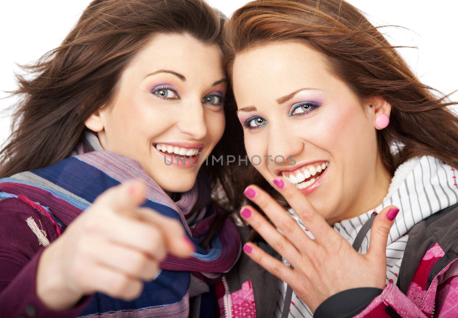 Two beautiful girls laughing and pointing at camera