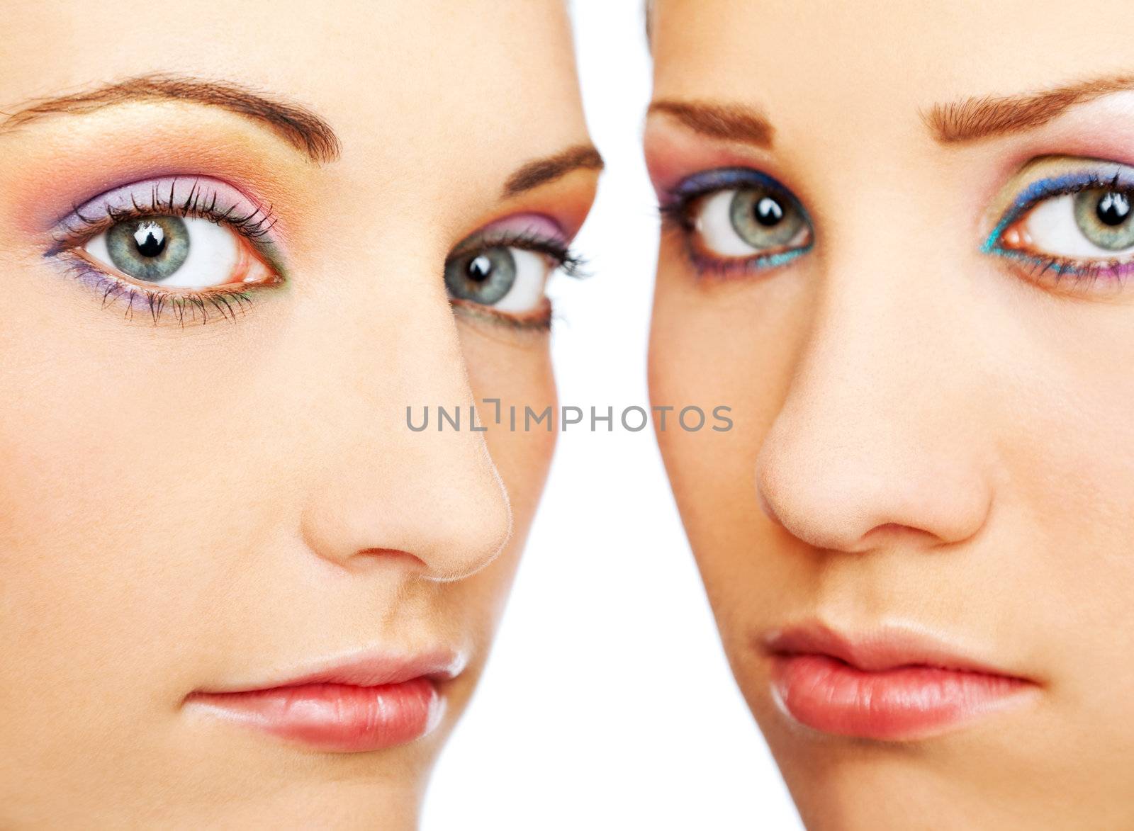 close up of two beautiful female faces with colorful makeup