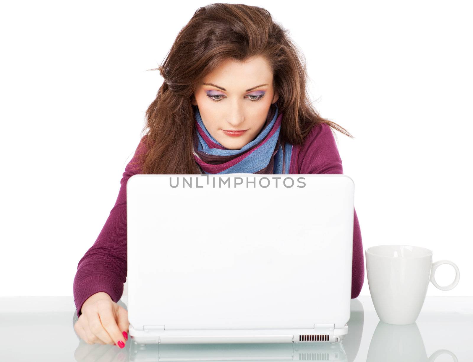 Young beautiful female sitting behind white laptop with a cup