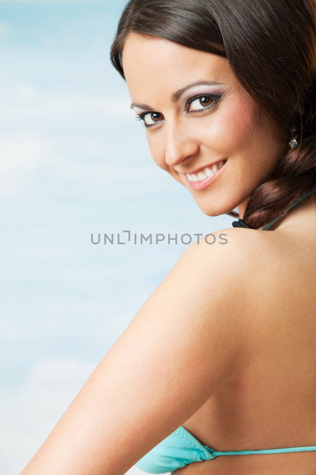 Close-up of beautiful woman with braid smiling in swimsuit