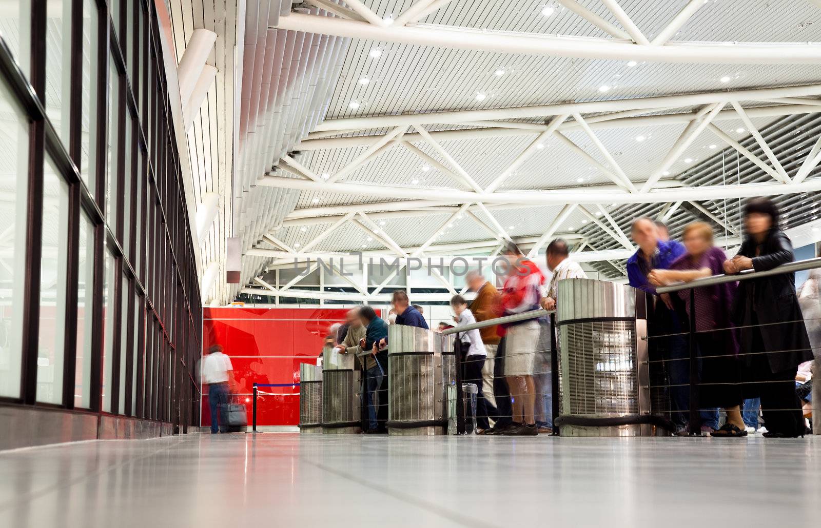 arrival section at airport with blurred figures of waiting people