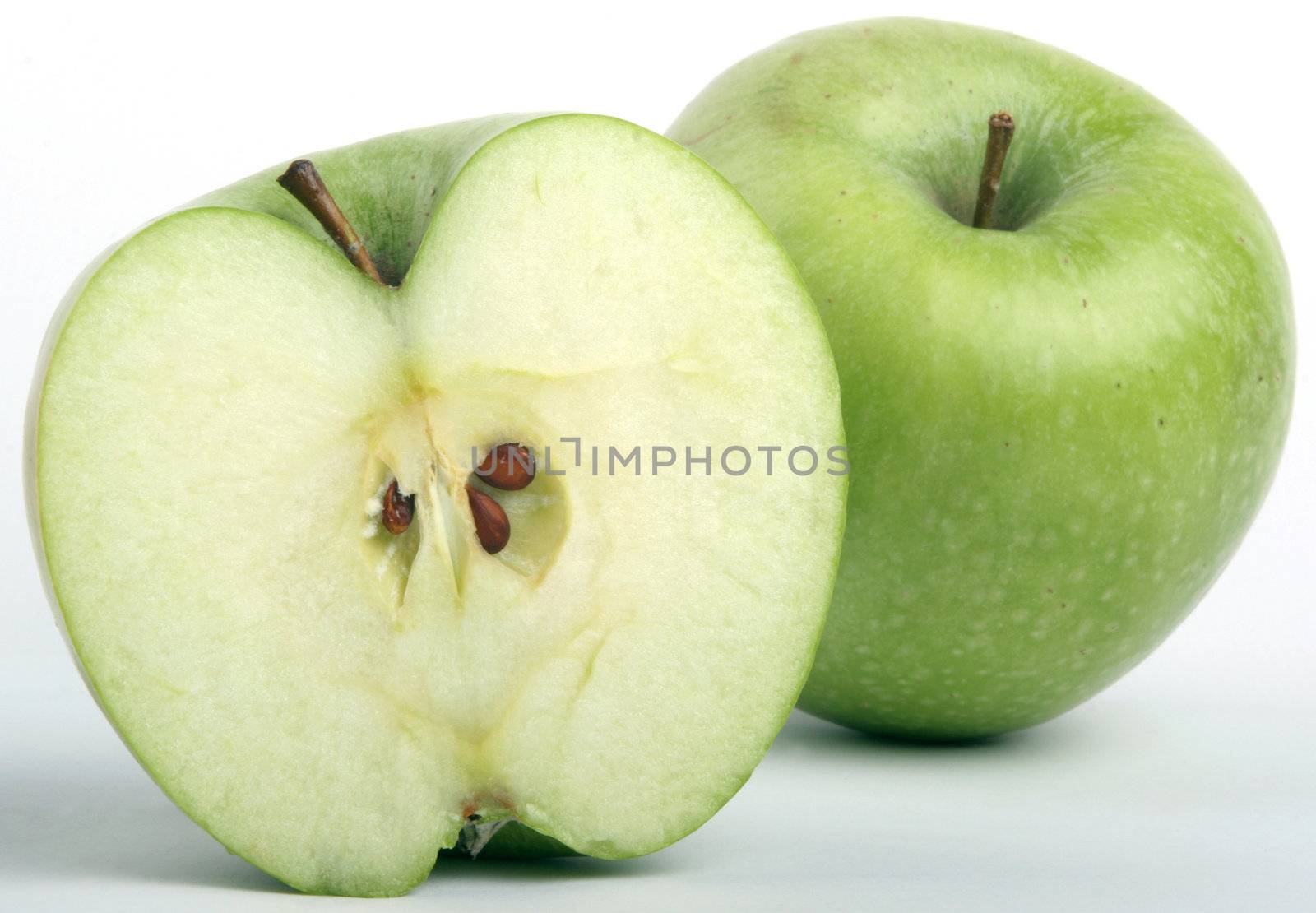 Half of a green apple and a whole behind