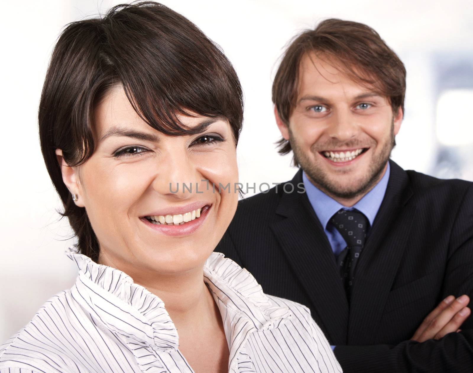 smiling business people. female infront of a male