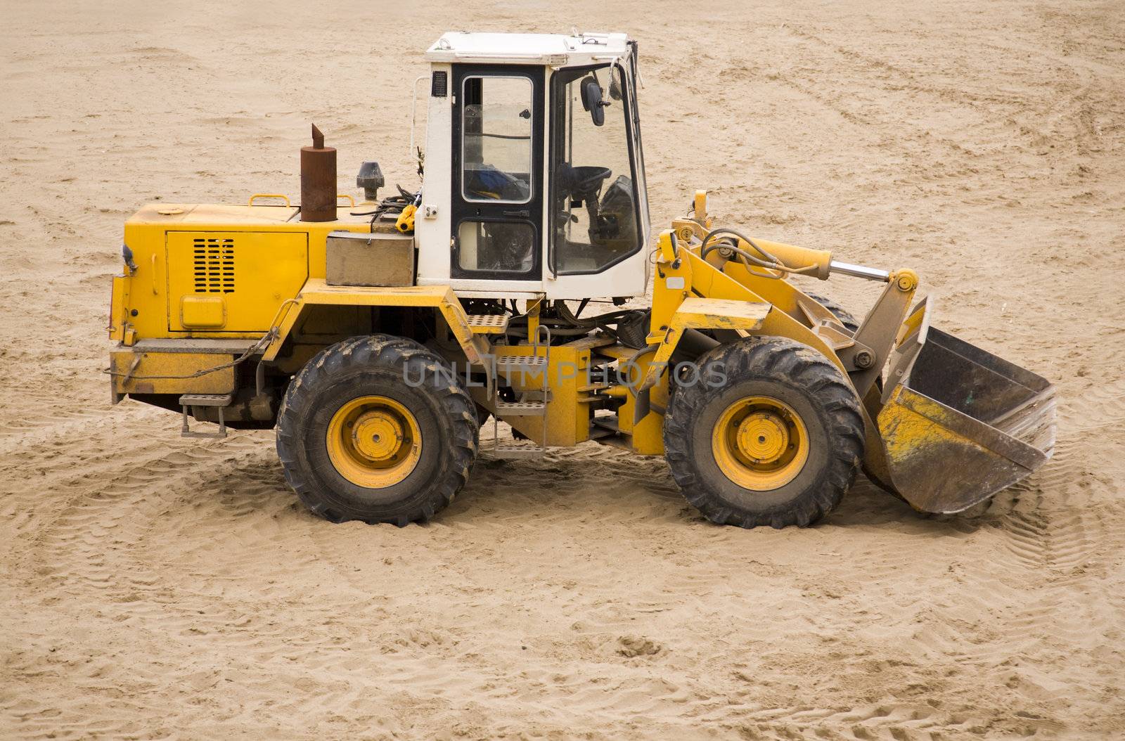 grunge and dirty tractor on sand surface (focus poit on machine selective)
