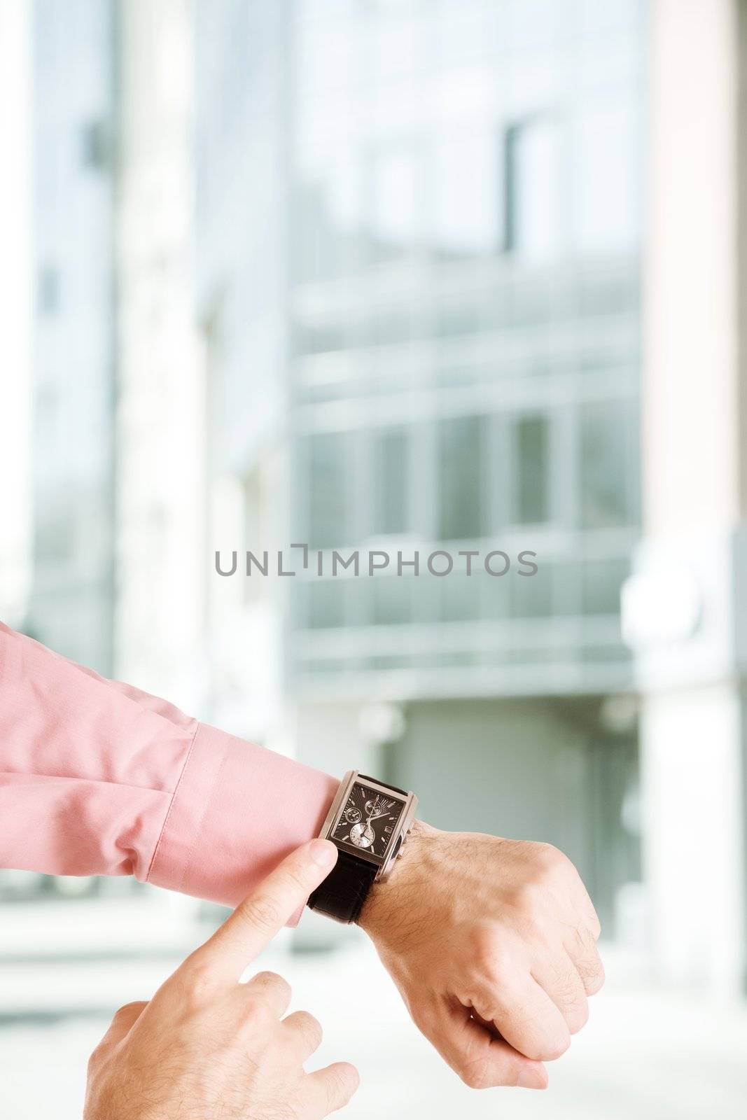 hands of the man with clock on urban background