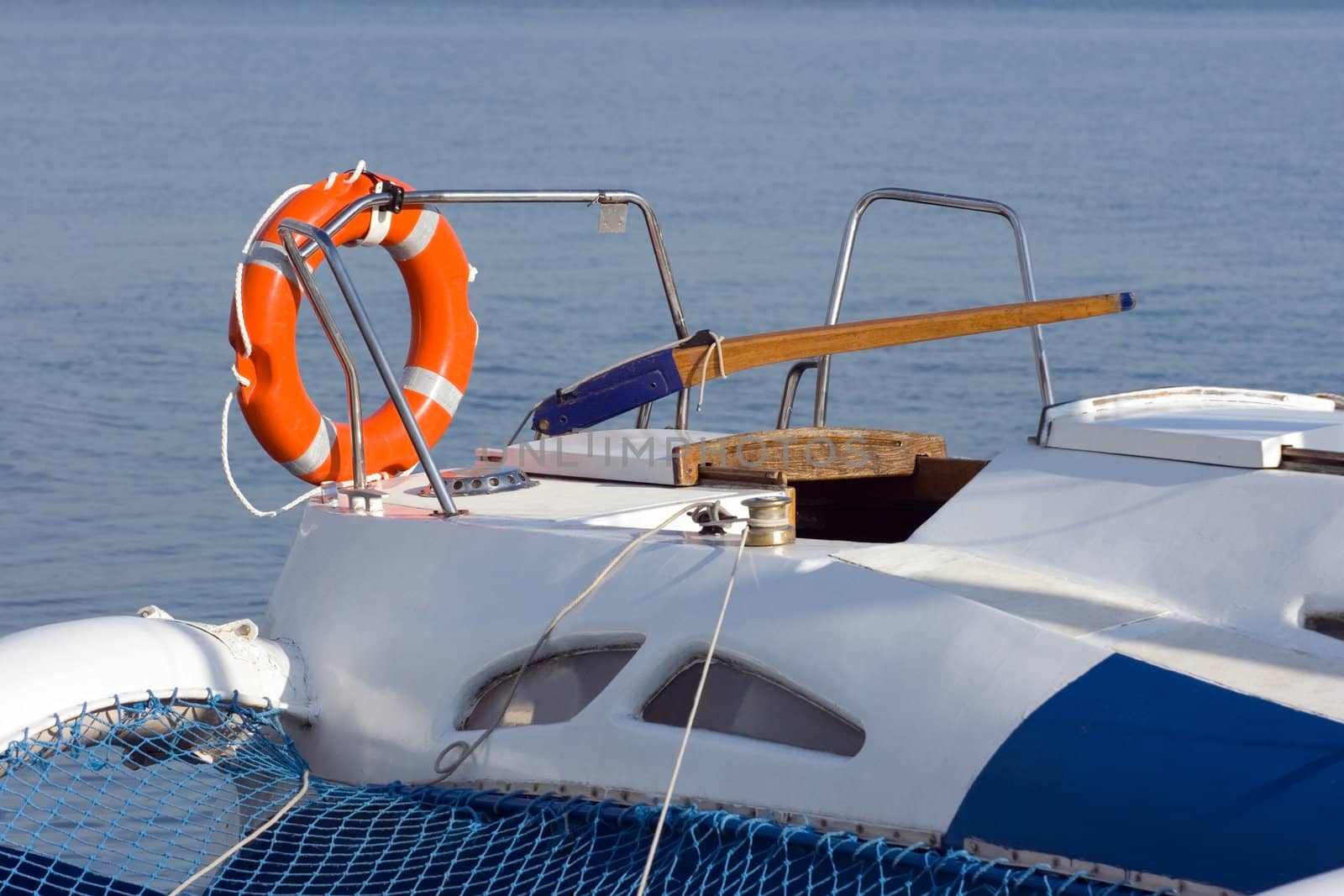 Orange lifebuoy ring on a forage of a sailing yacht