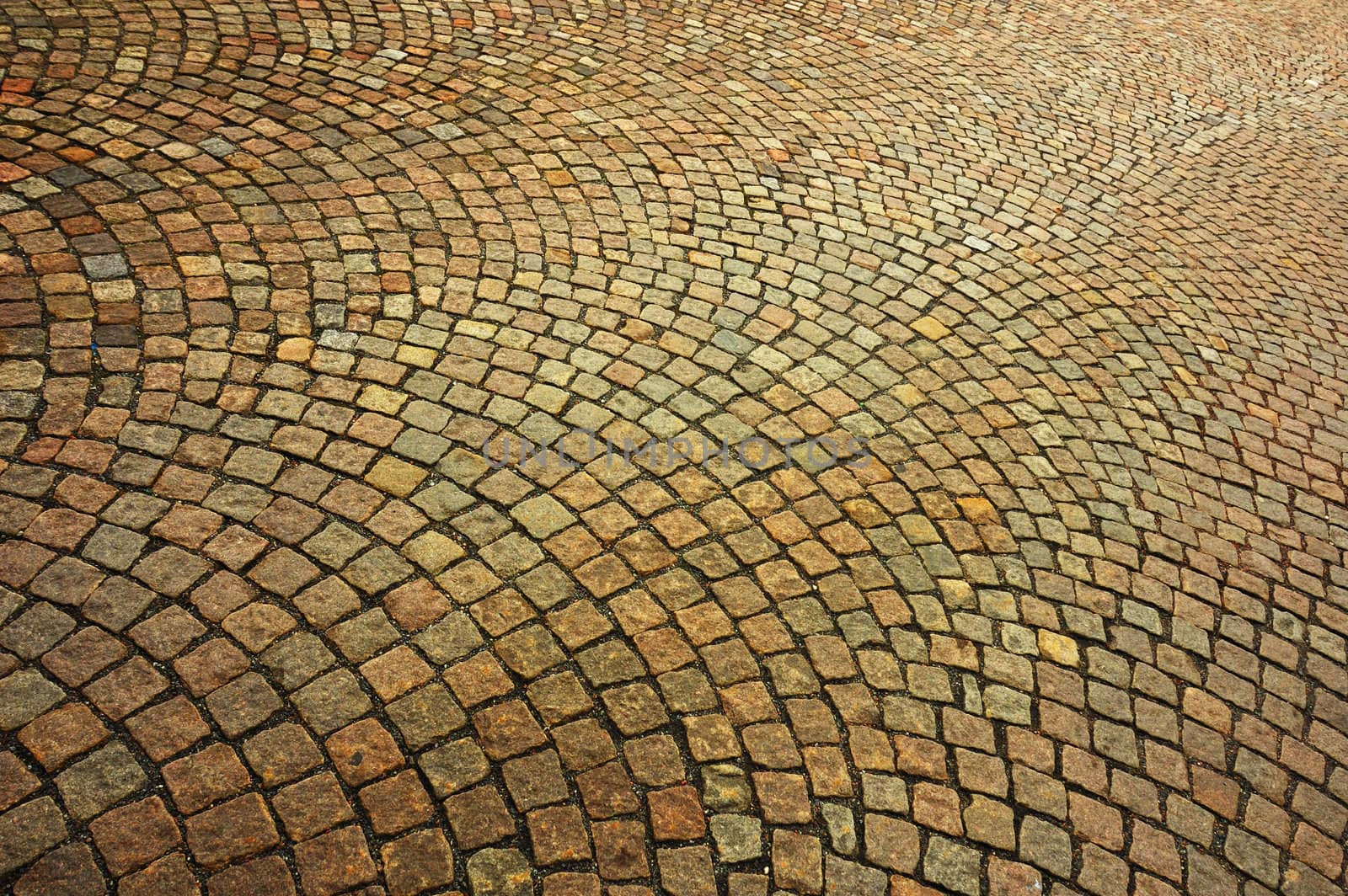 Detail of a patterned cobbled courtyard stretching away into the distance.