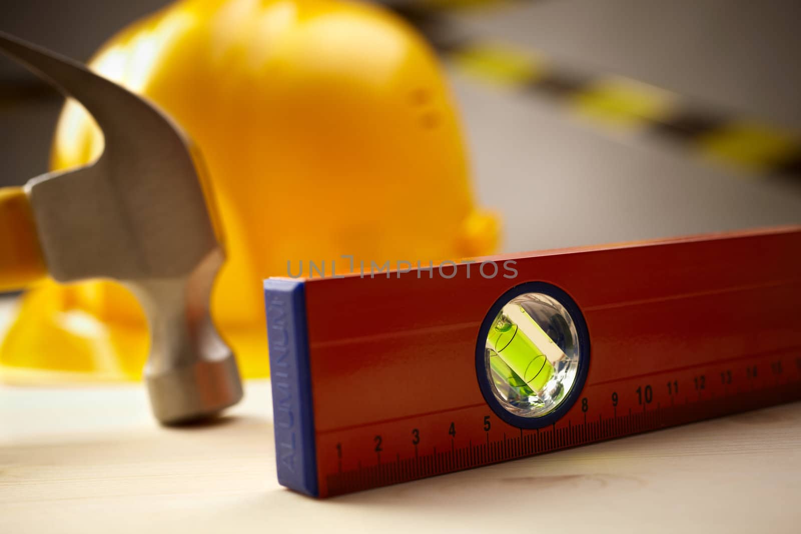 industrial concept with level,hammer and yellow hardhat, selective focus