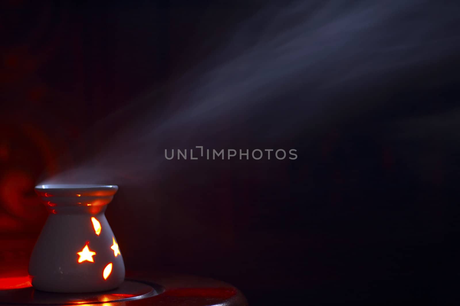 Smoking oil incense on a wooden background