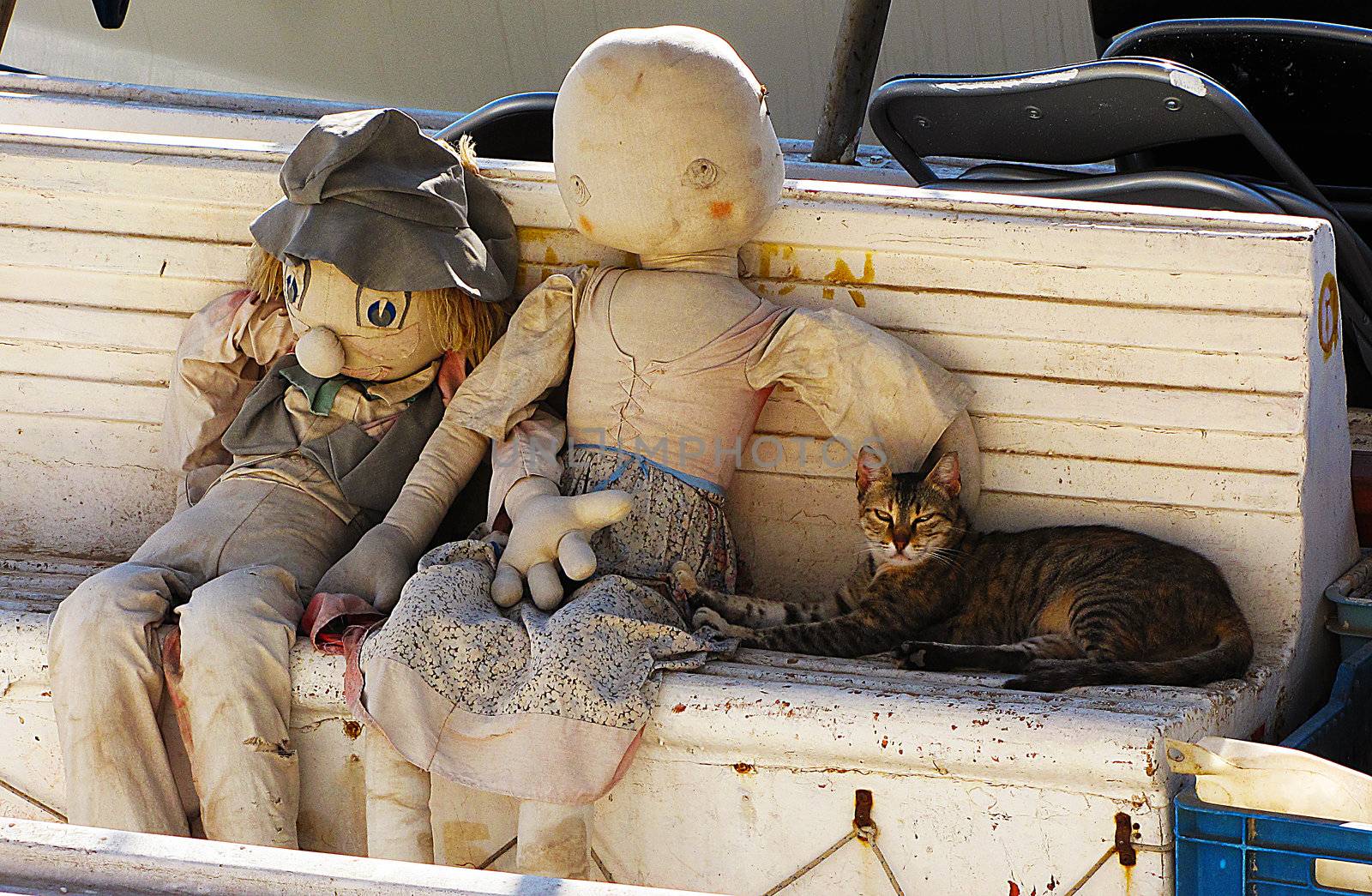 Two puppets and a cat on a wooden bench