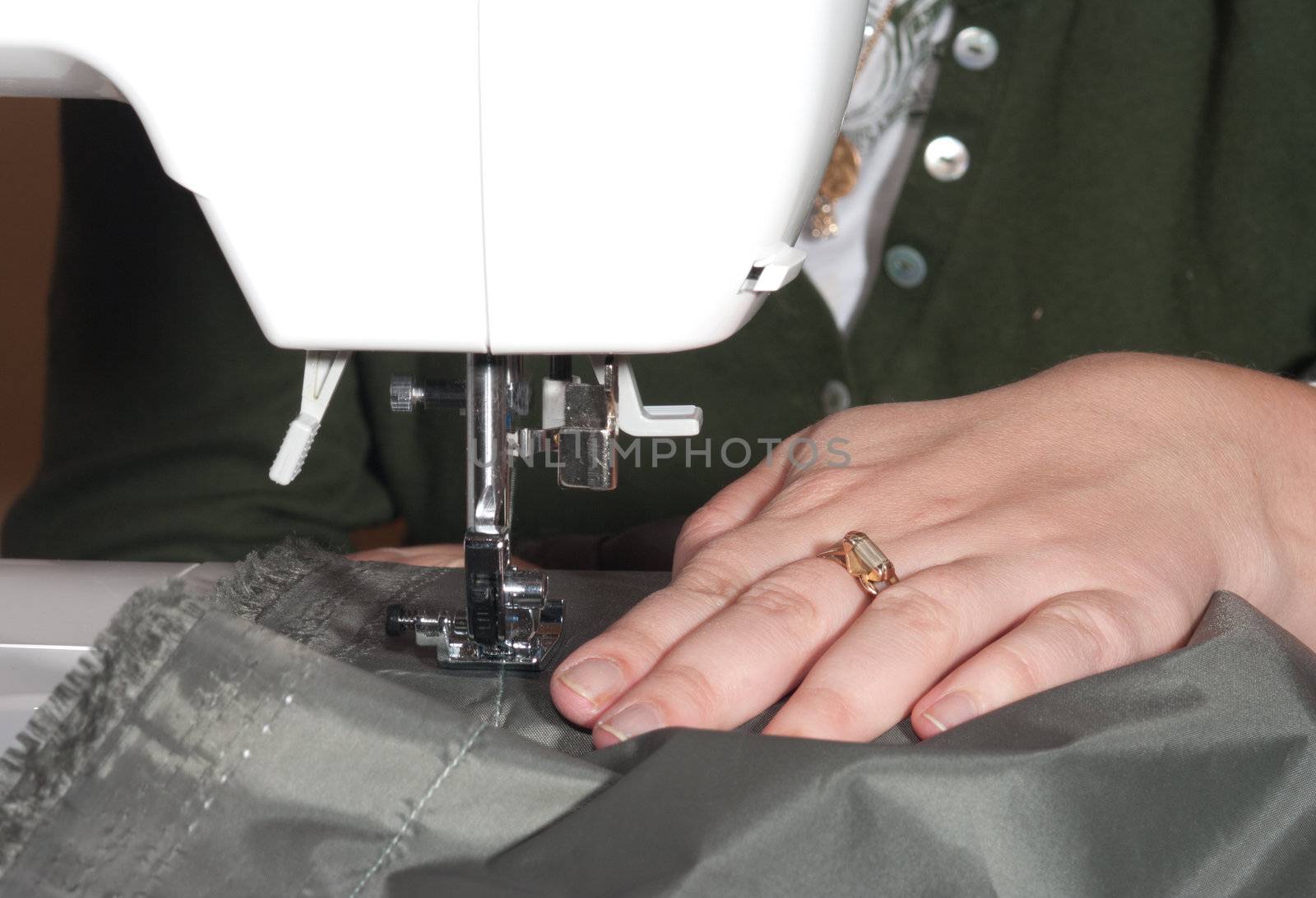 Female hands sewing on a machine.