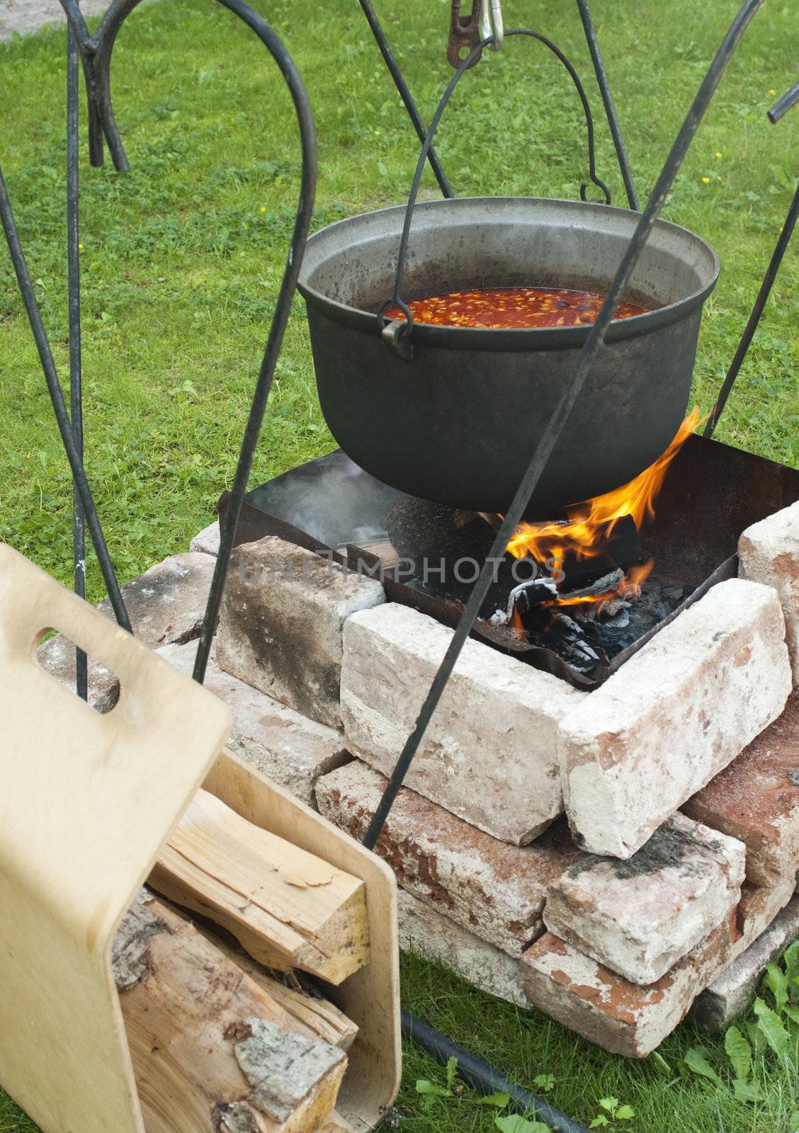 Cooking of soup in the pot on fire