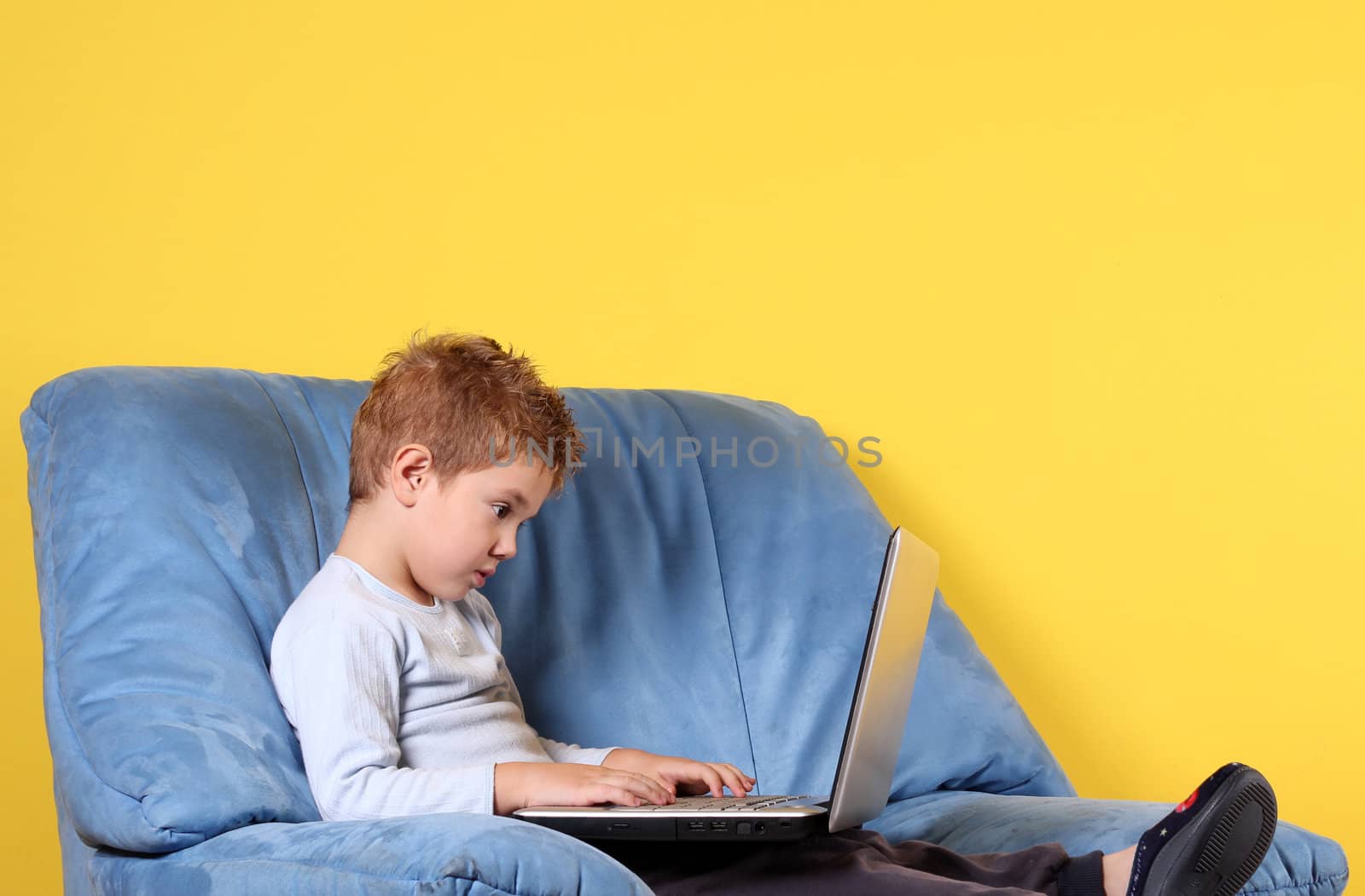 boy typing on laptop by goce