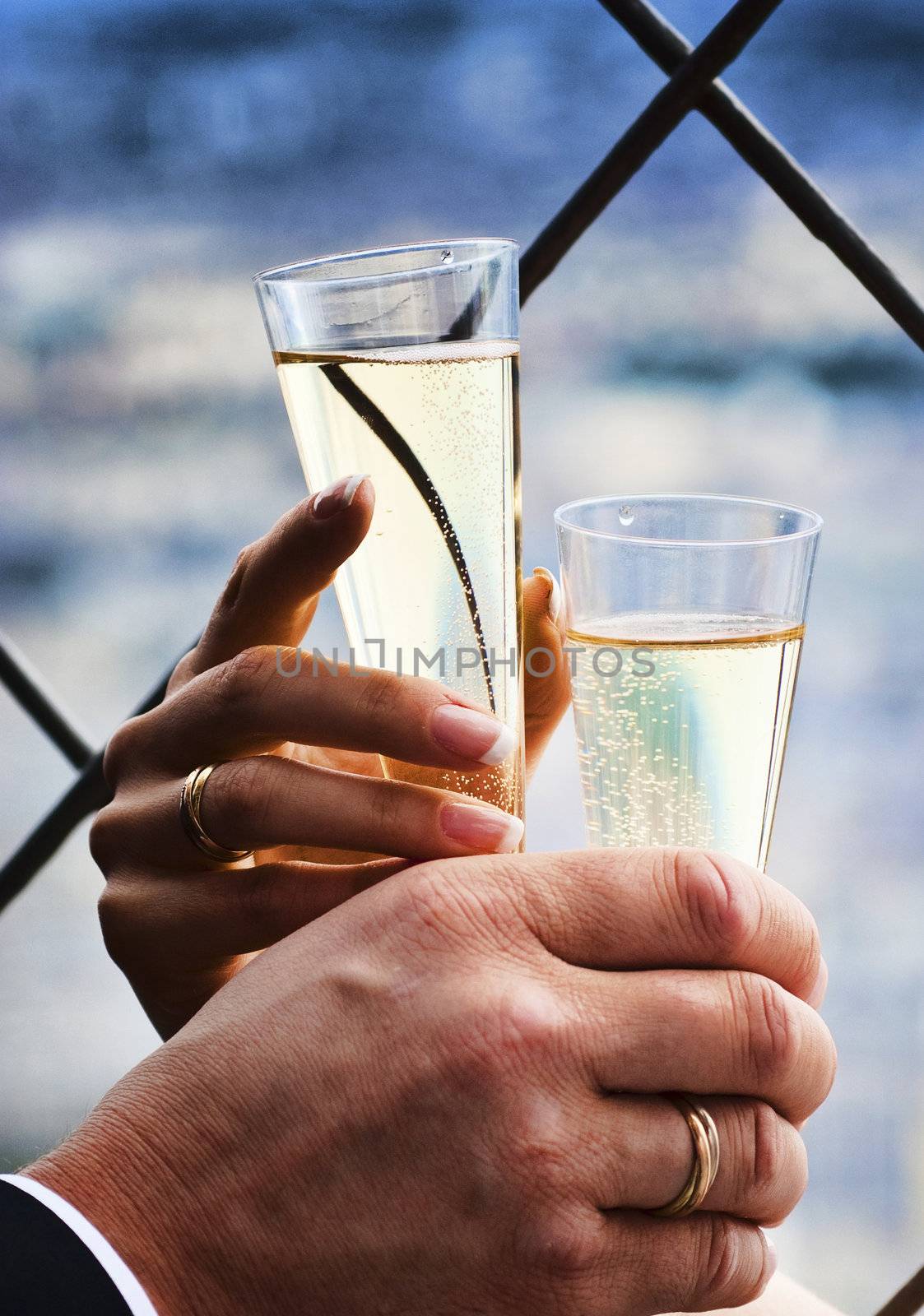 Two hands holding glasses with wedding champagne