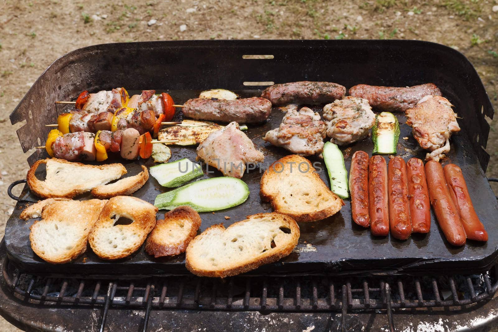 barbecue with meat, sausage, bread and vegetables