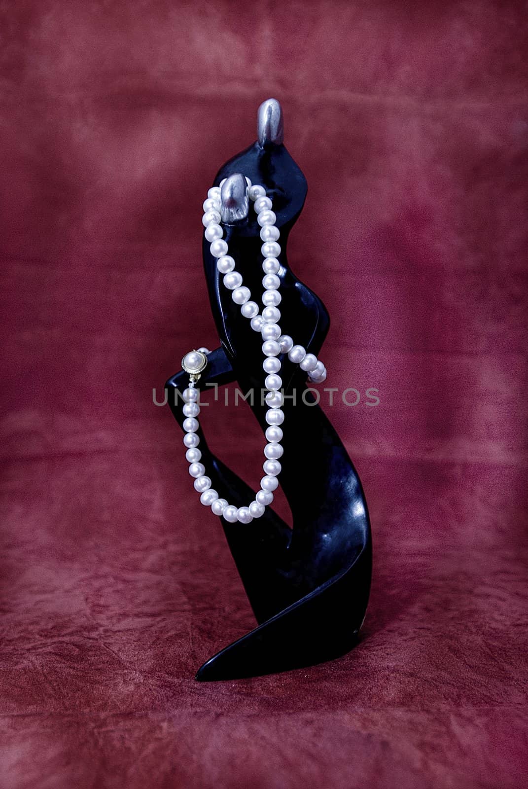 White pearl necklace tied on wooden statuete
