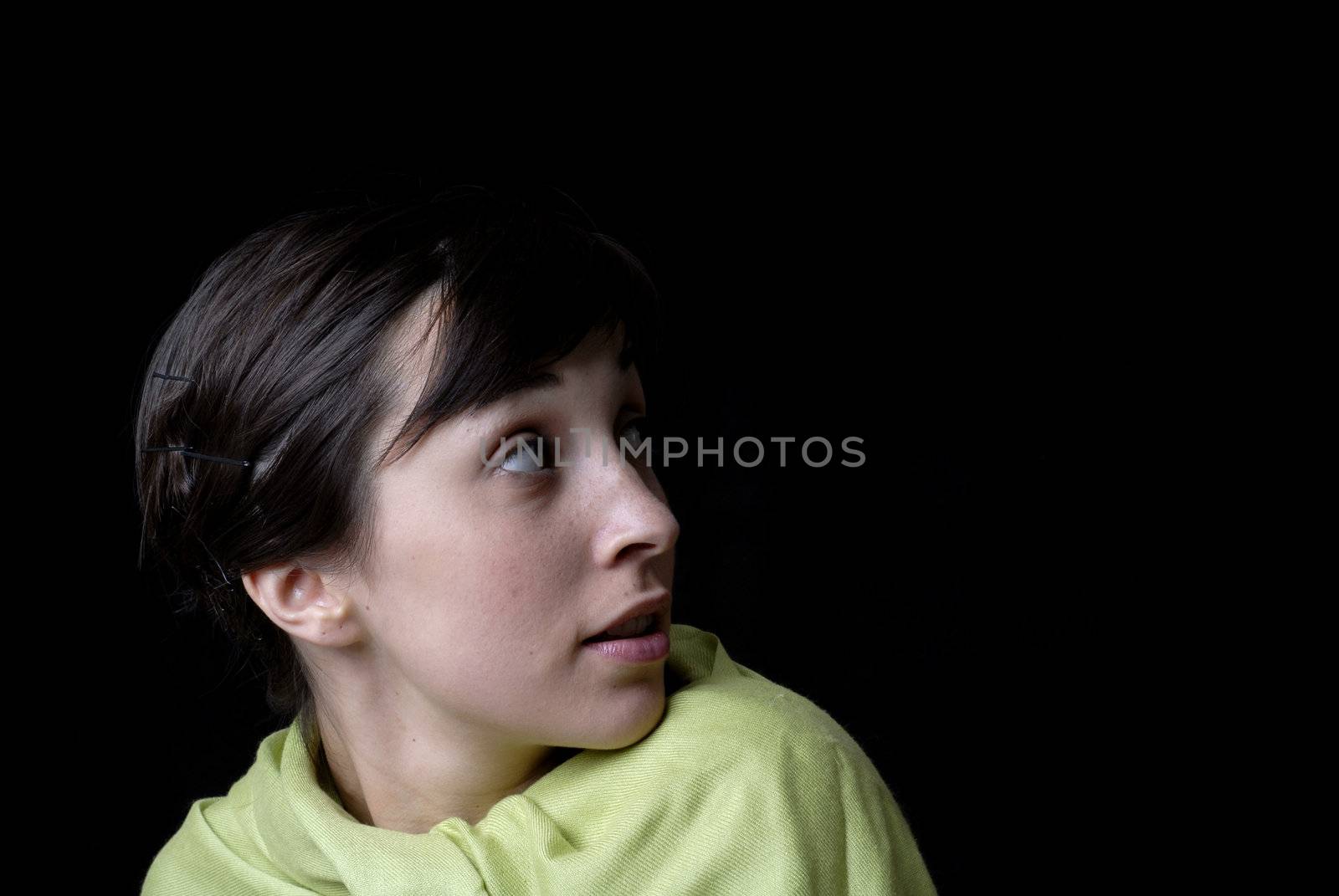 Portrait of a brunette young girl in black background