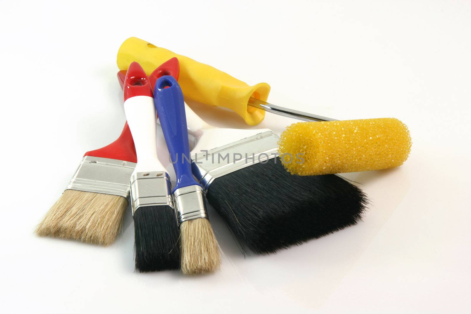 four paint brushes and paint roll on white background hardware tools
