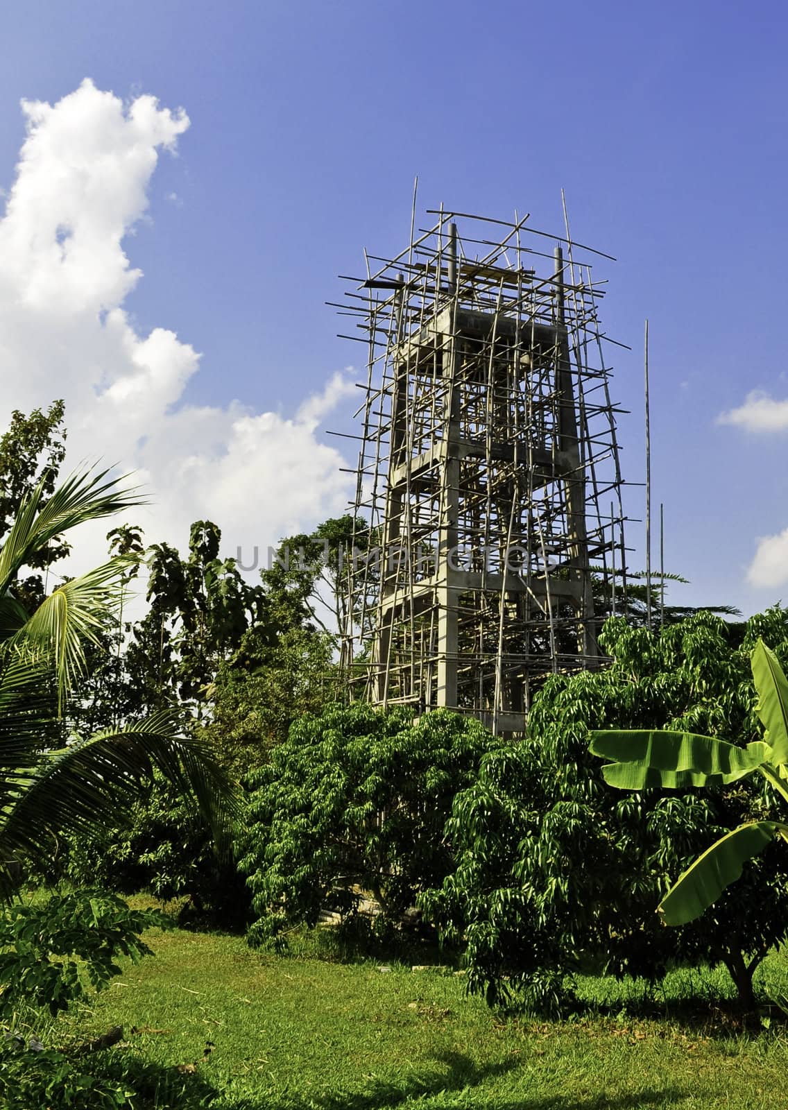 A large tower being constructed in a rural area of Asia