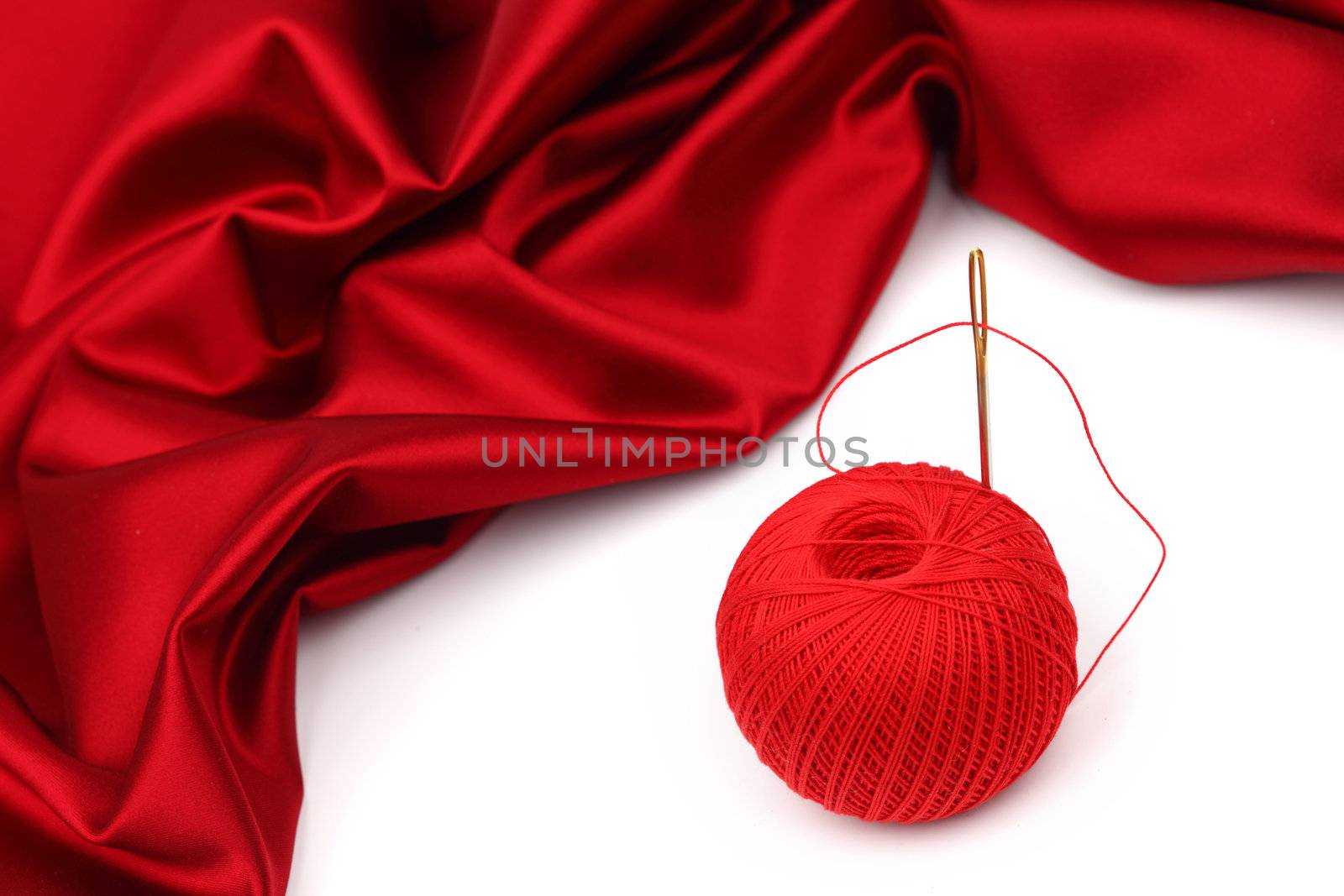 red satin and thread isolated on white
