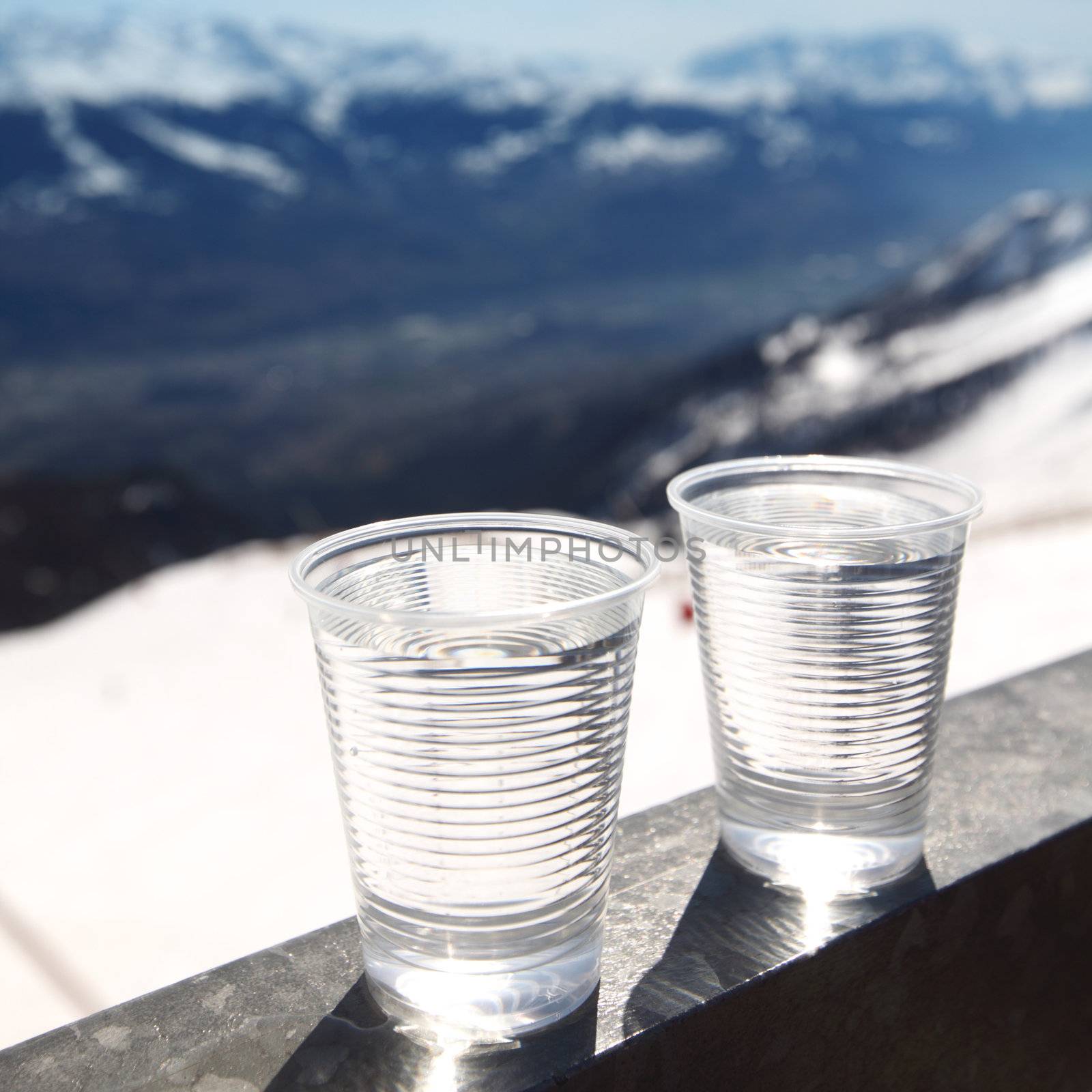 water in cup mountains on background