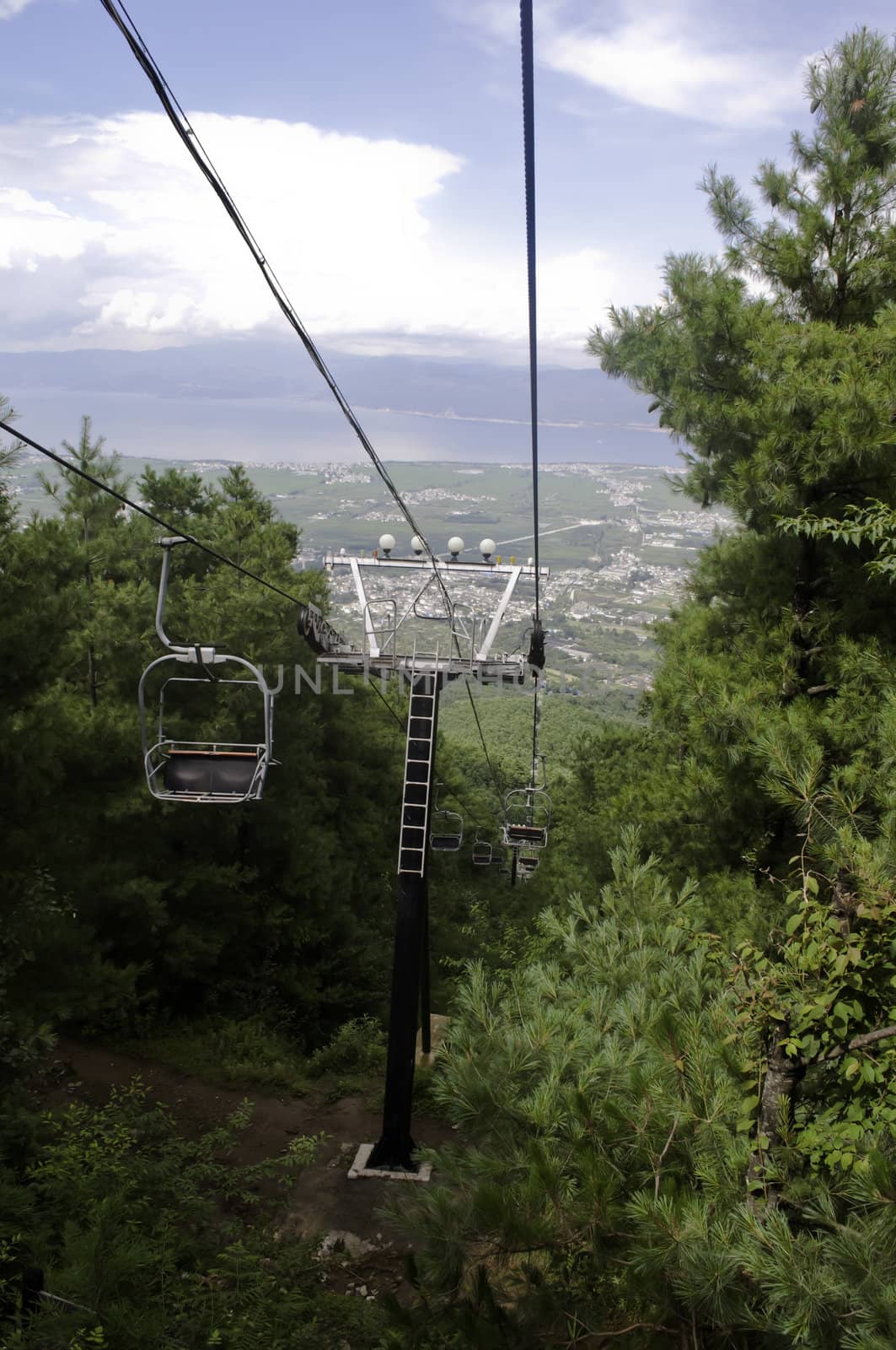 A chairlift going up a mountain pass in summer