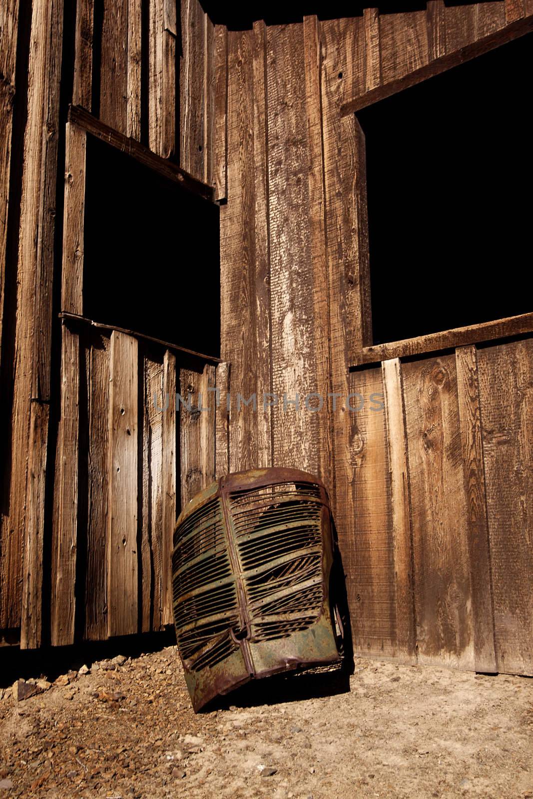 A rusty old truck grill against a barn. by jeremywhat
