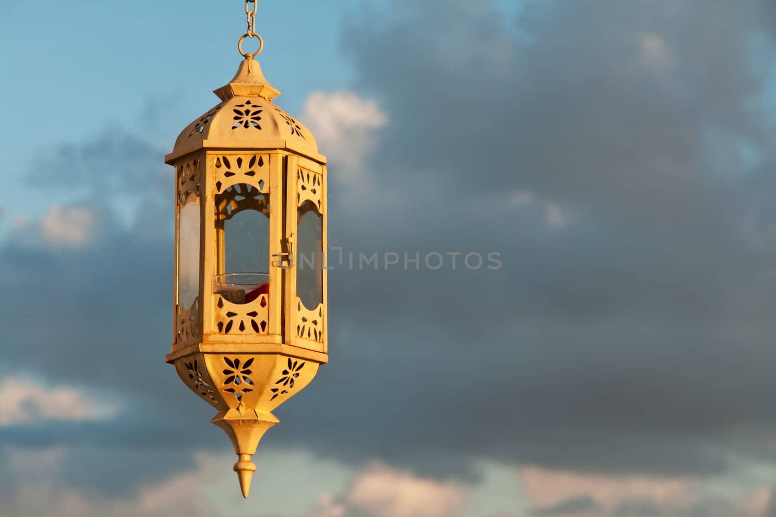 Beautiful hand crafted old vintage lantern over the blue sky background