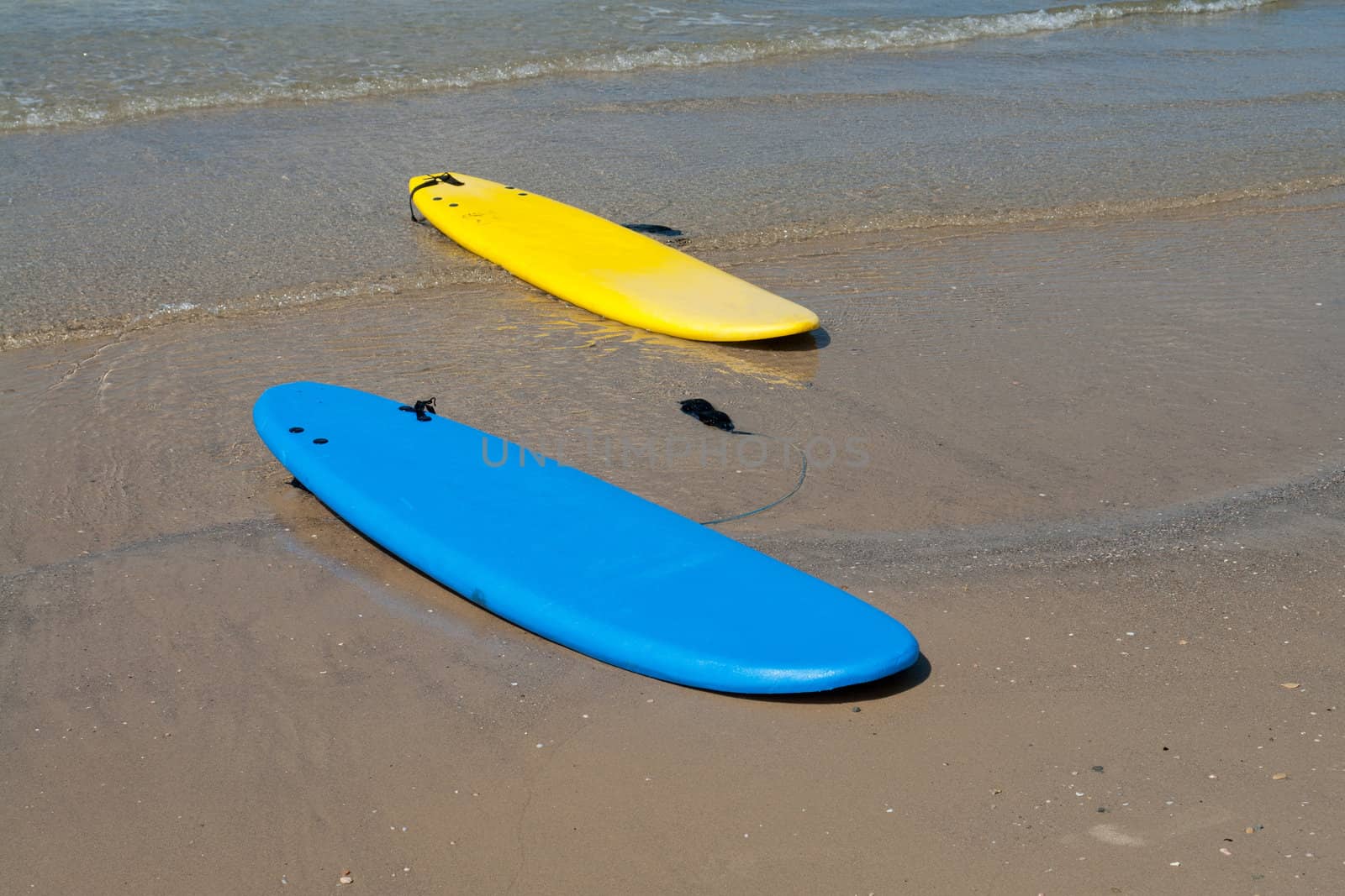 Colorfull surf boards on a  sandy beach ready for extreme action sport