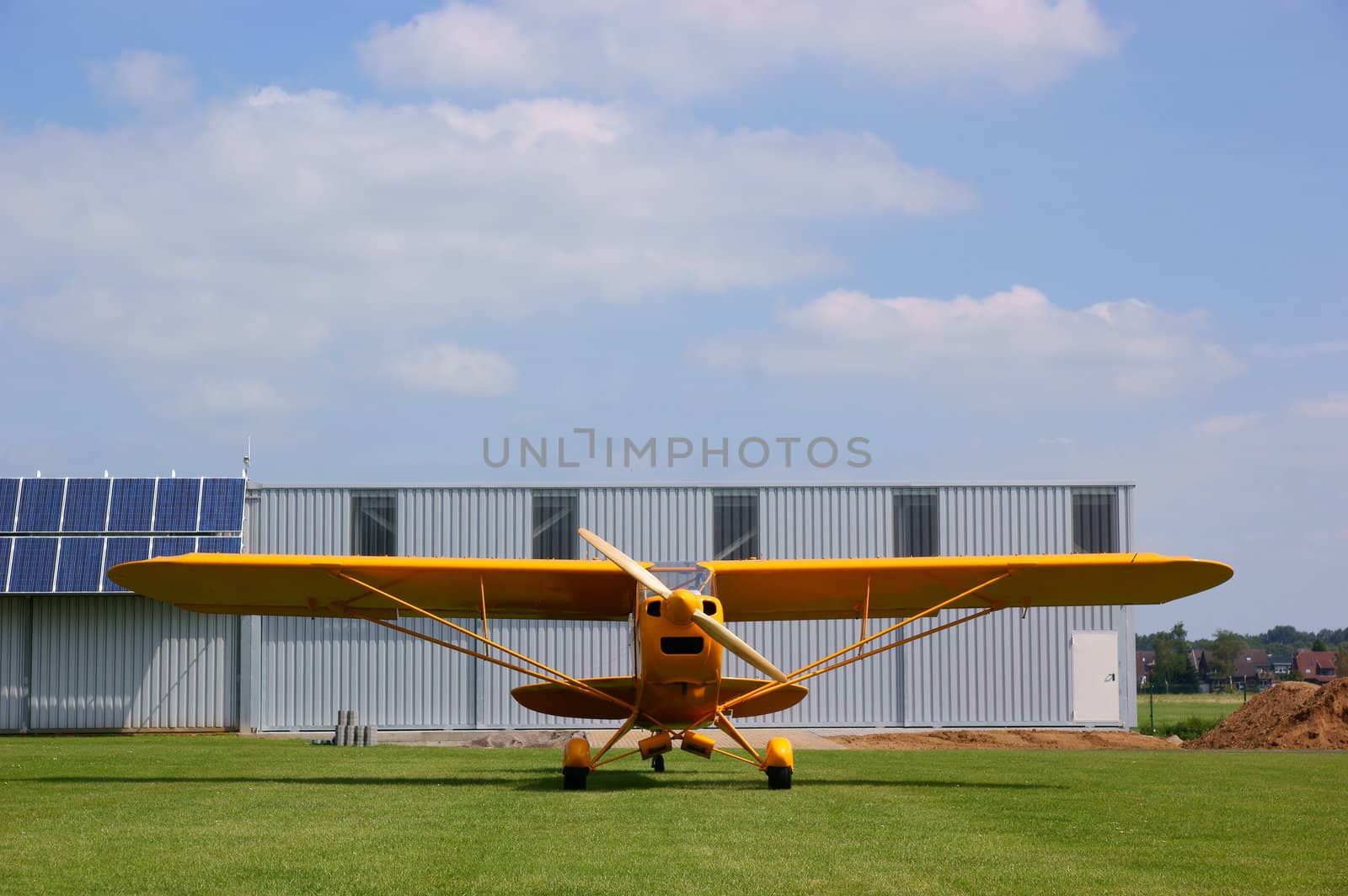 Small yellow airplane on a small airstrip