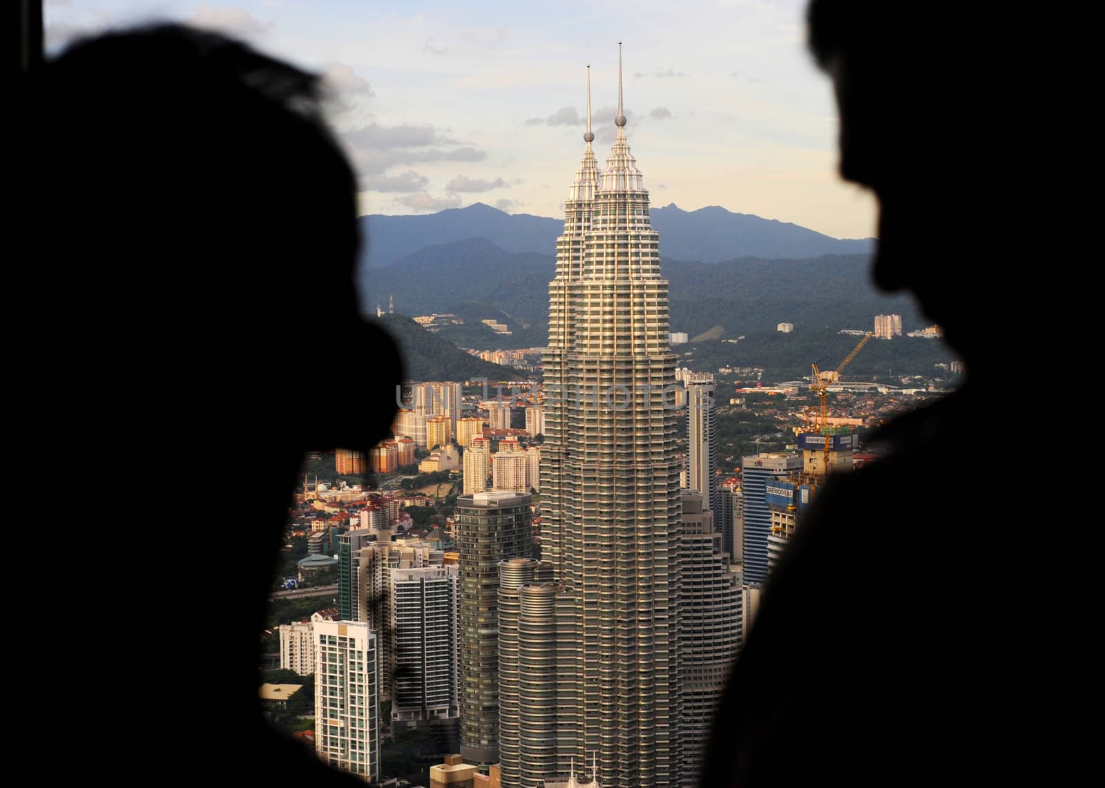 Kuala Lumpur, Malaysia - March 30, 2011: People looking to Petronas Twin Towers from viewpoint of Kuala Lumpur Tower ( Menara). The Petronas Towers are the tallest twin buildings in the world.