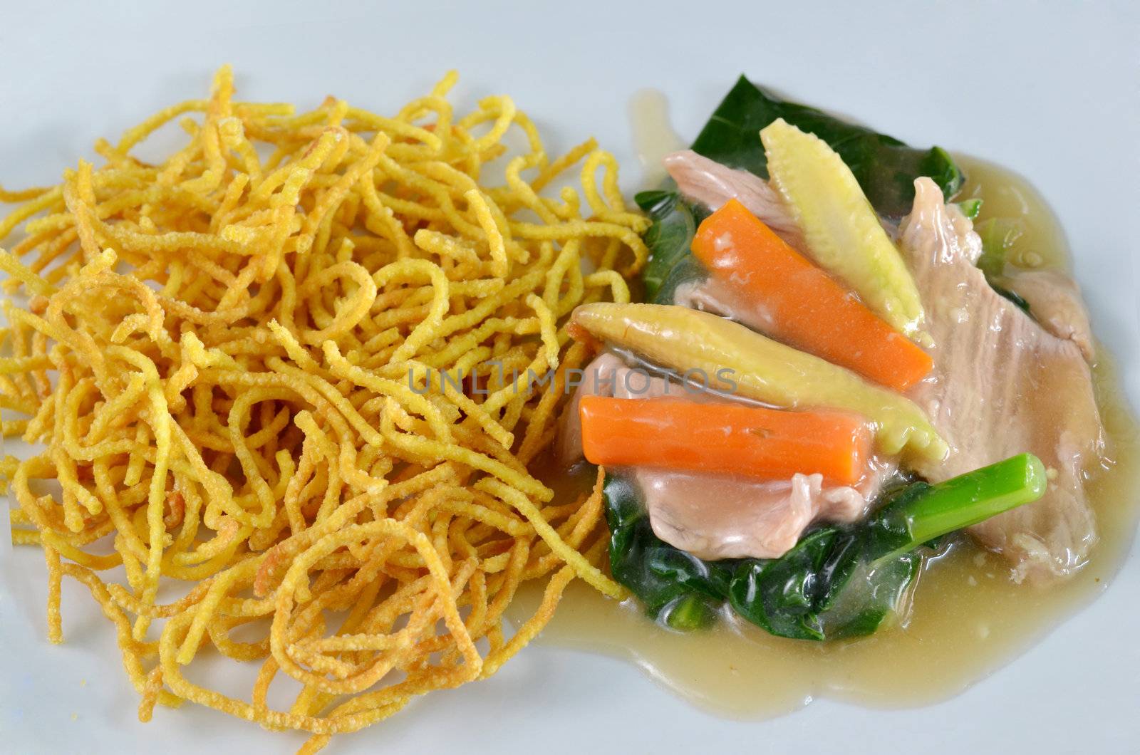 crispy yellow noodle with in a creamy gravy sauce 
