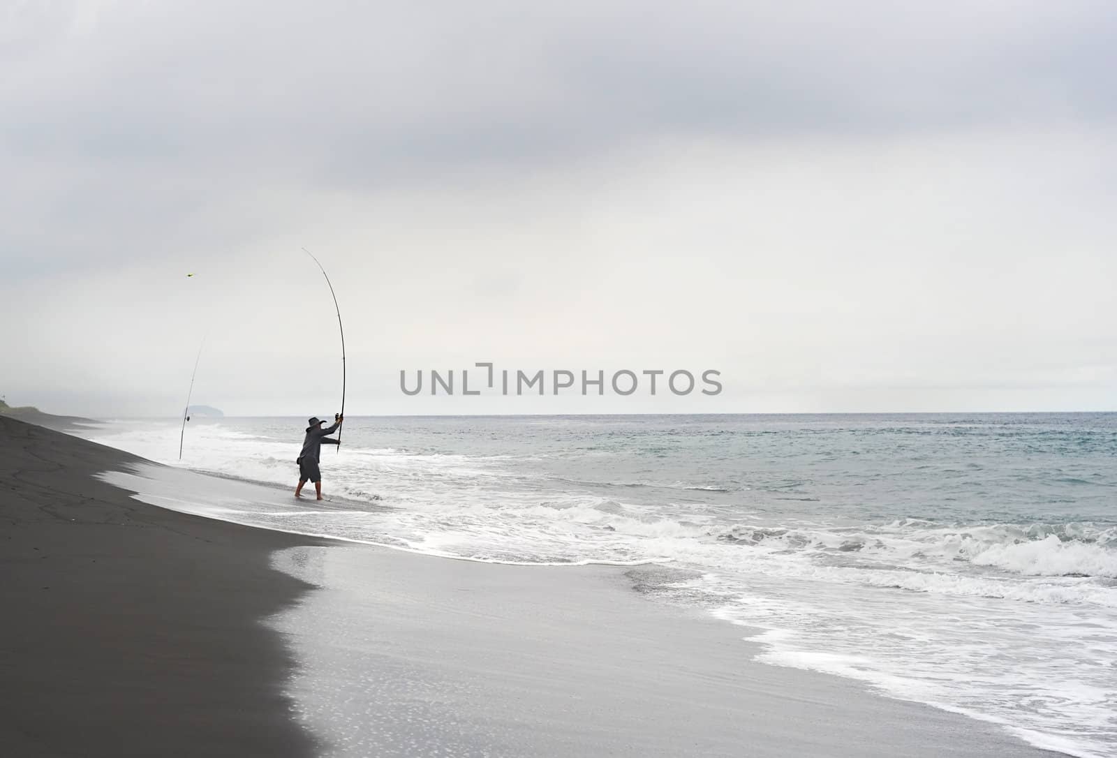 Bali, Indonesia - April 8, 2011: Fisherman catching fish on the ocean beach
