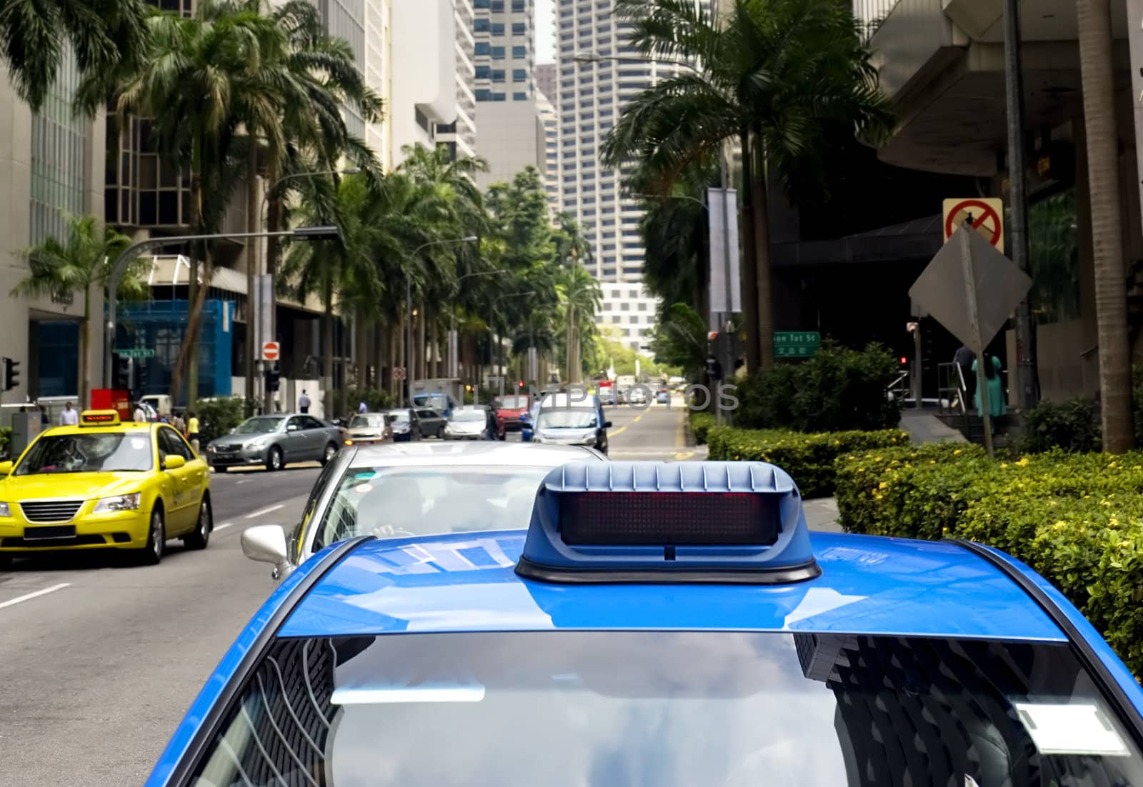 Taxi in the central sreet in Singapore. Sharpness on a blue car