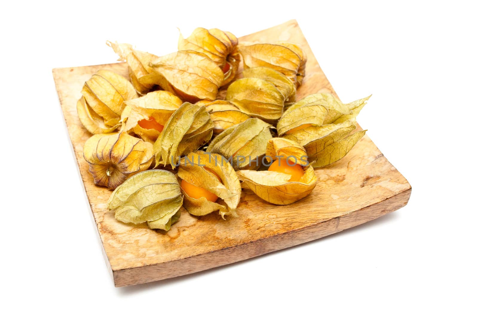 Physalis fruits on a wooden dish on white background
