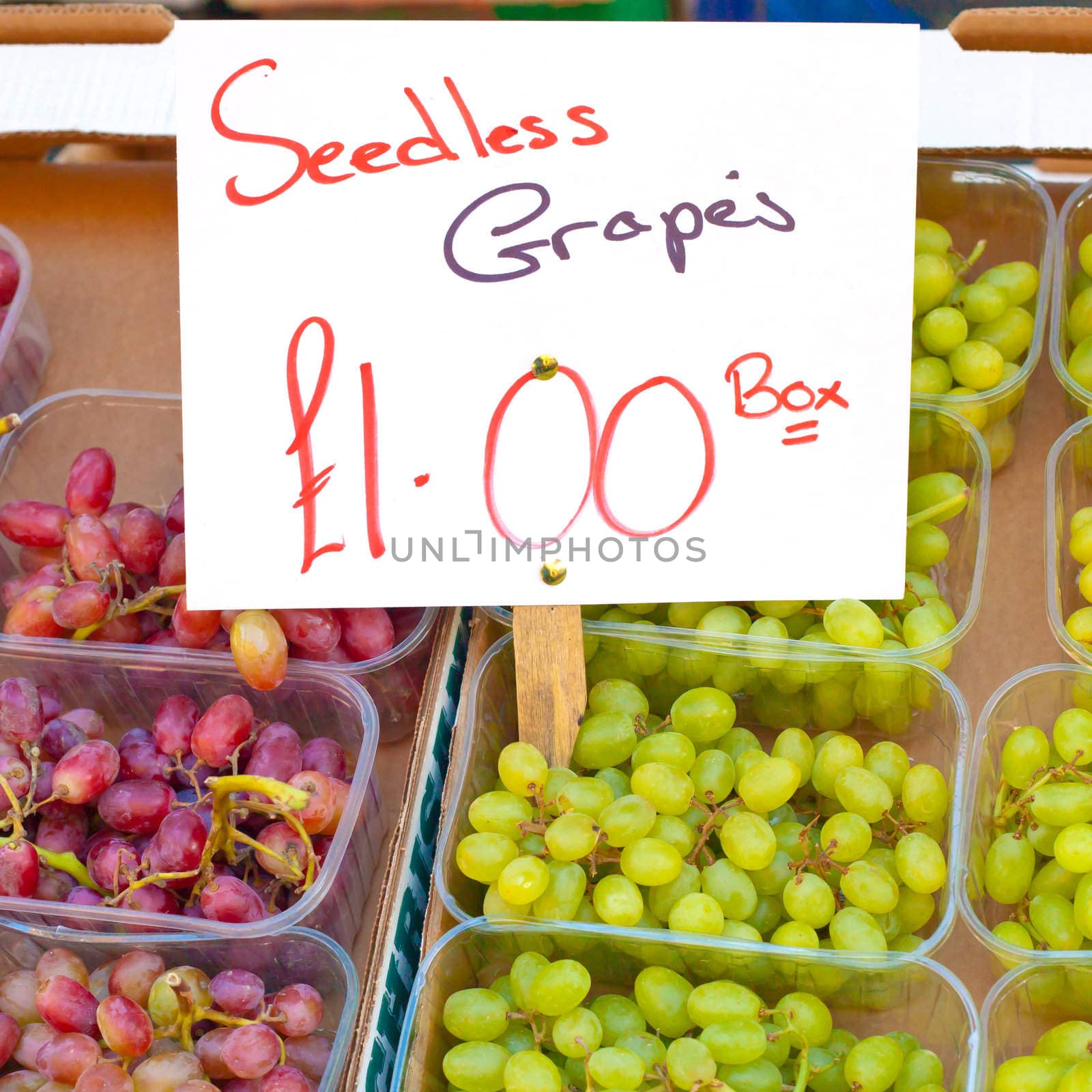Punnets of red and white grapes for sale at a UK market stall