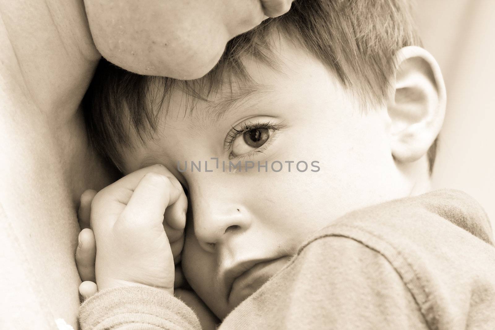 Nice image of a young upset boy cuddling his mum