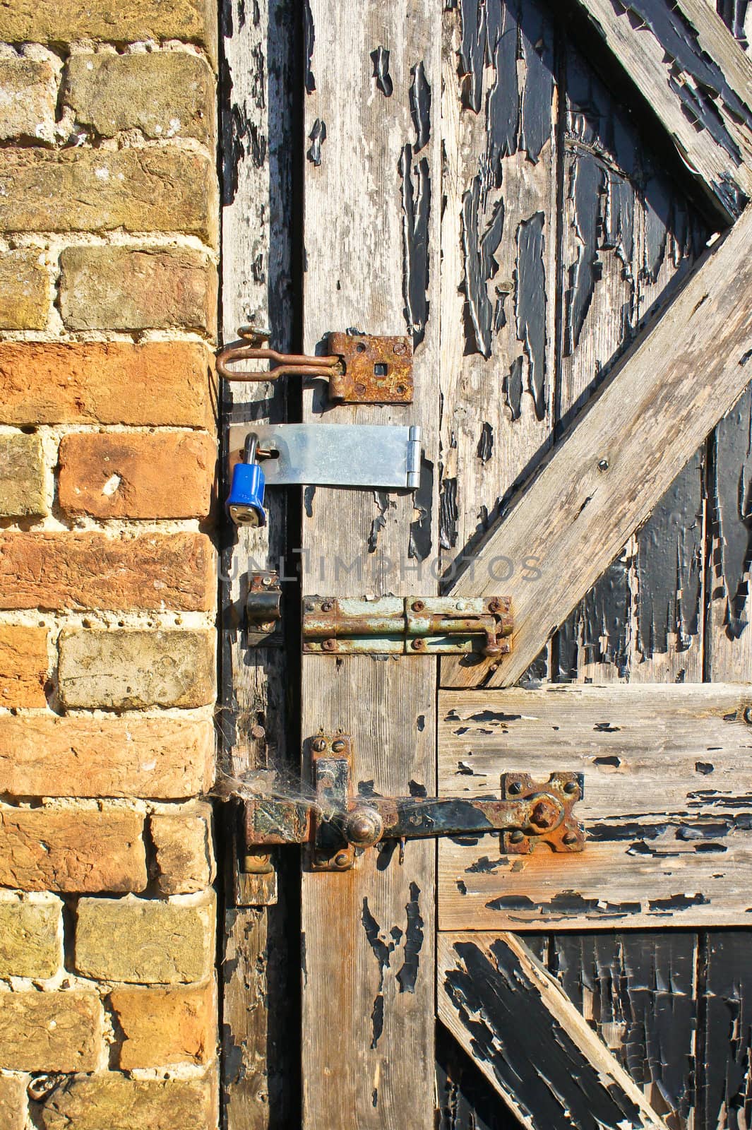 Close up of a weathered door with several locks