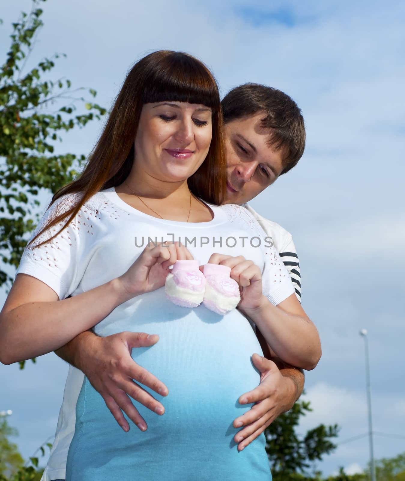 man and the woman lay together on cover,  smiling pregnant woman