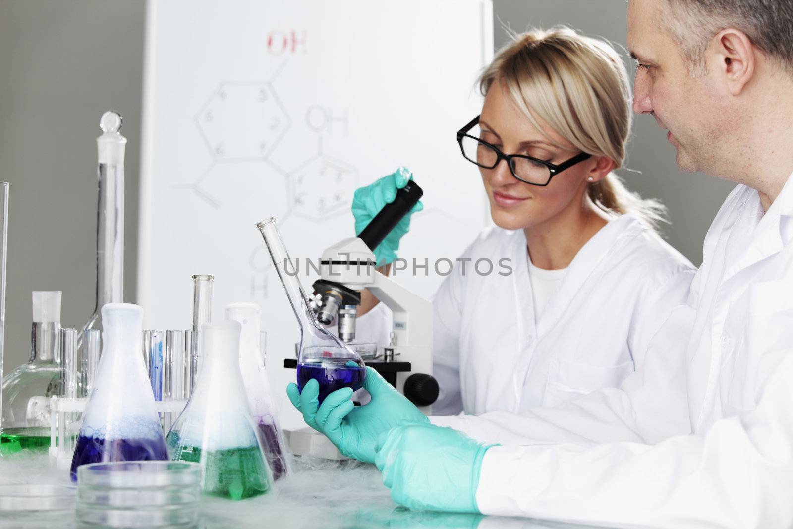 two scientist in chemical lab conducting experiments