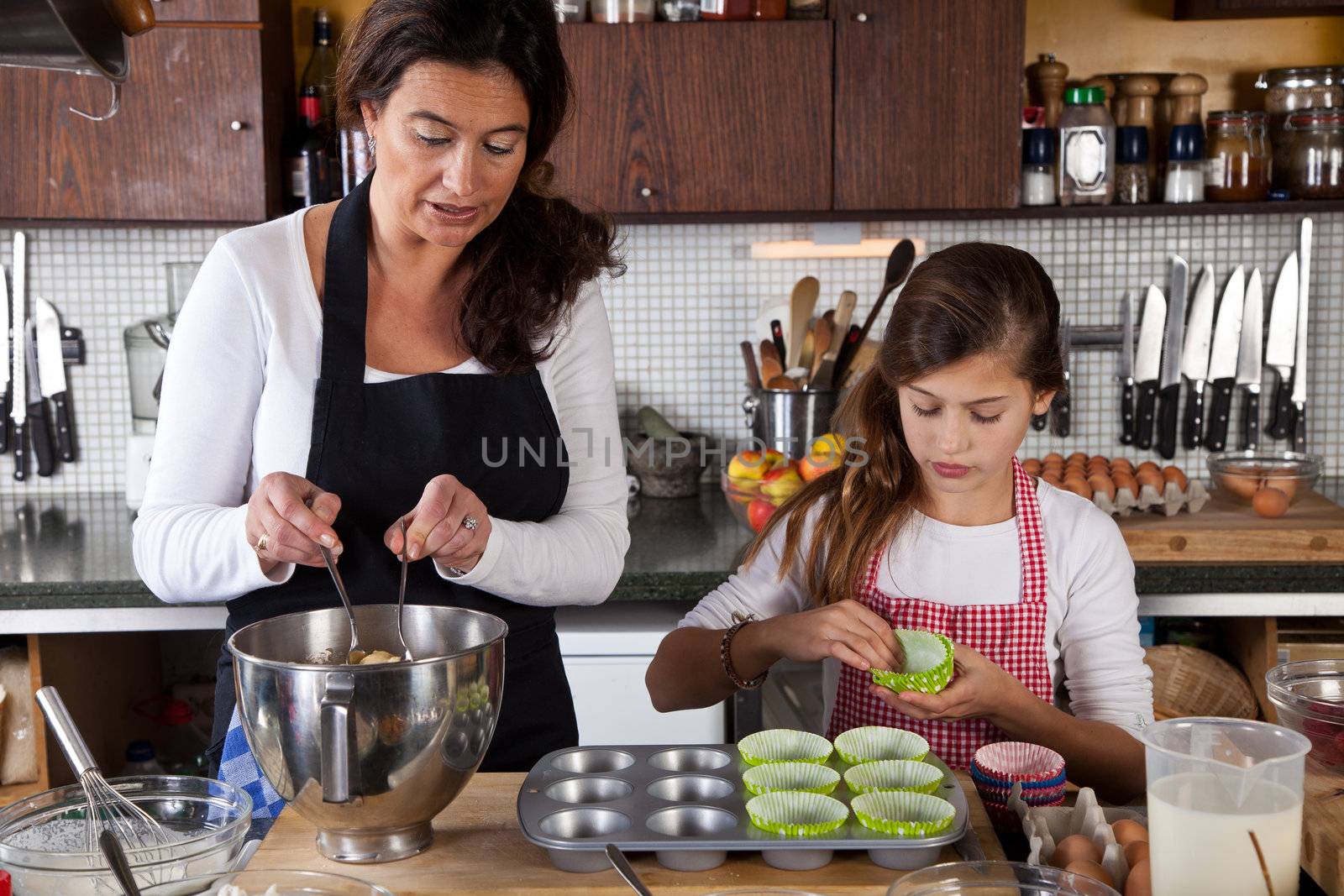 Mother and daughter baking at home by Fotosmurf