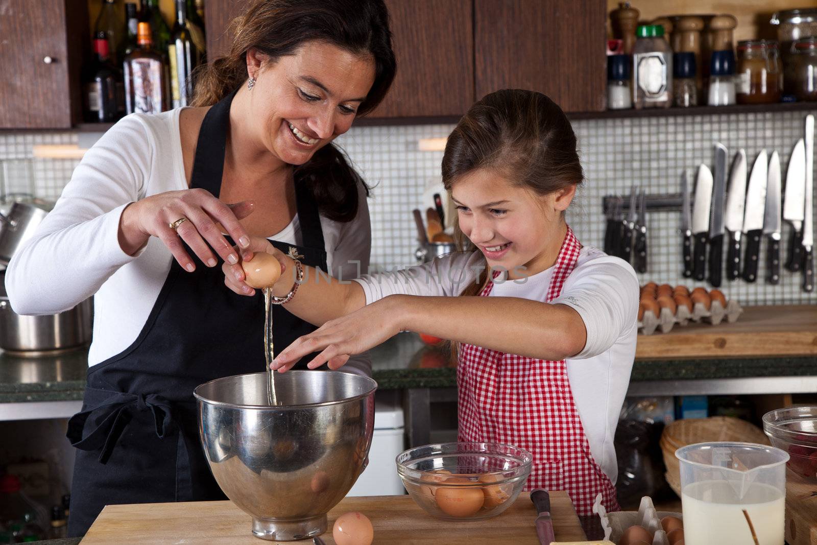 Mother and daughter having fun while baking in the kitchen