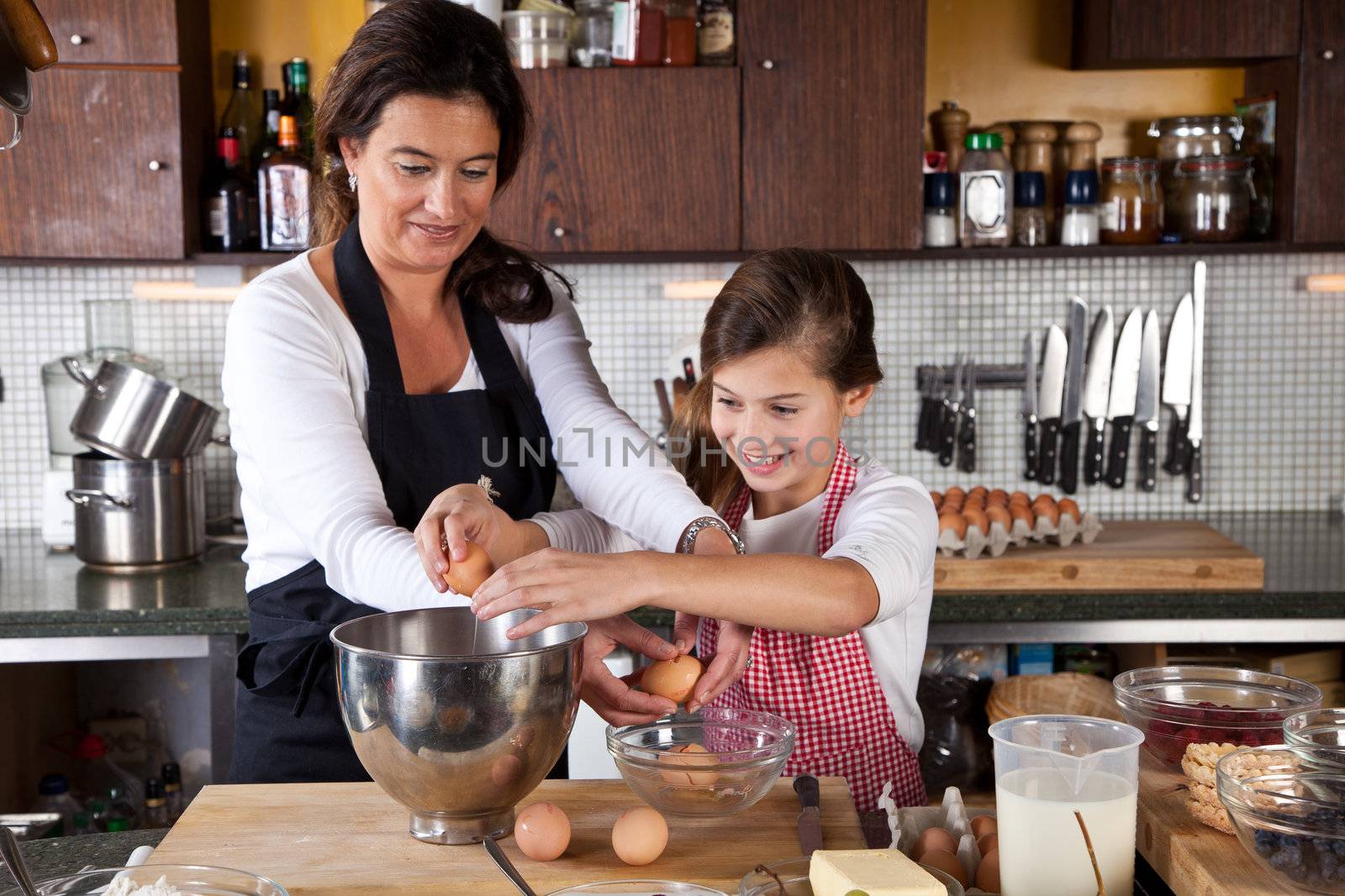 Mother and daughter baking cake together in the kitchen