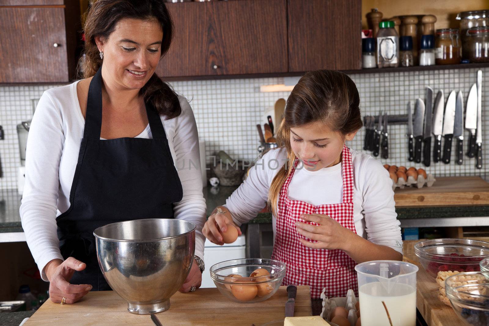 Mother and daughter having fun in the kitchen baking together