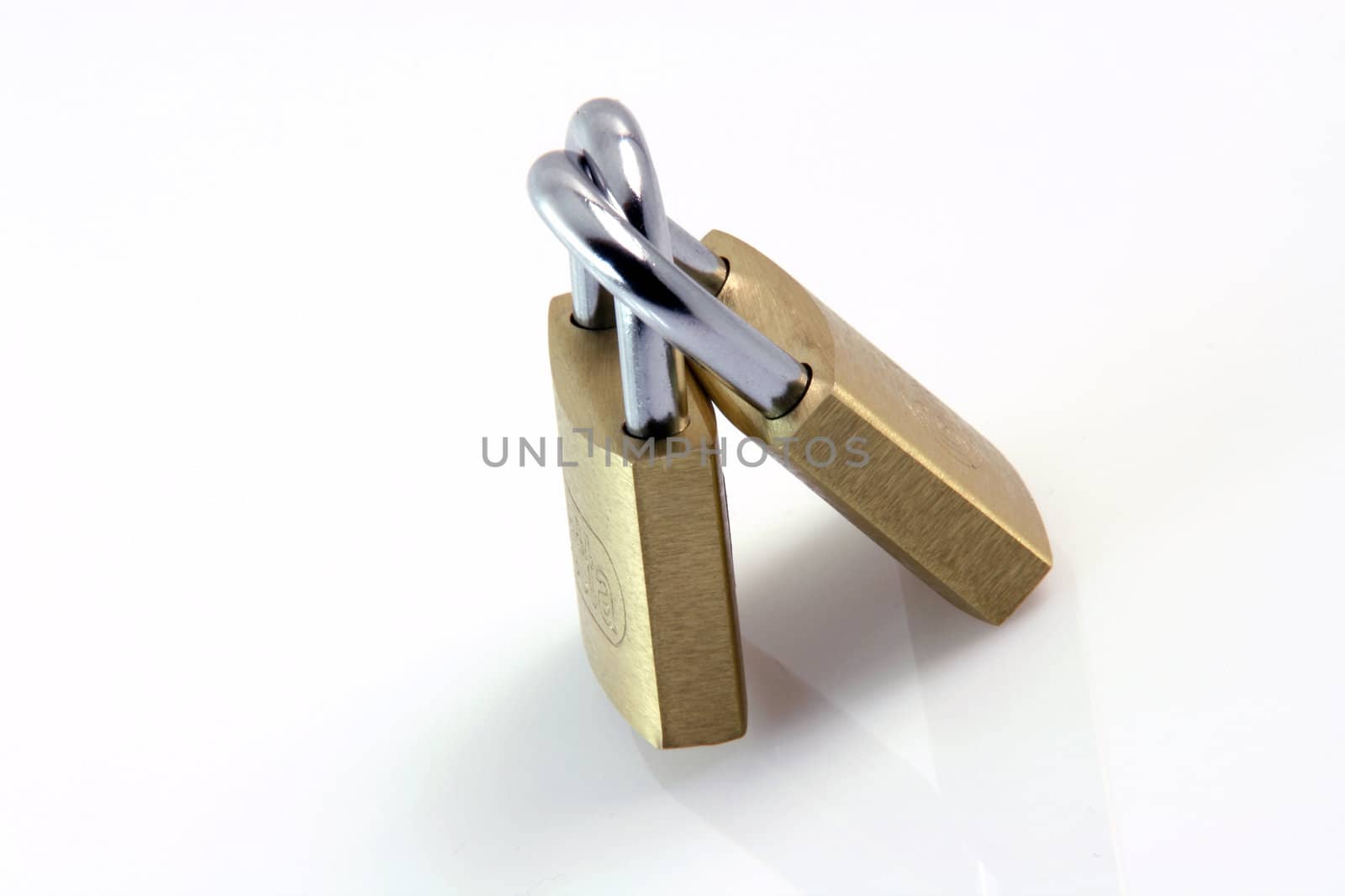safety and security concepts two metalic padlocks locked each other isolated on white background and a small reflection horizontal