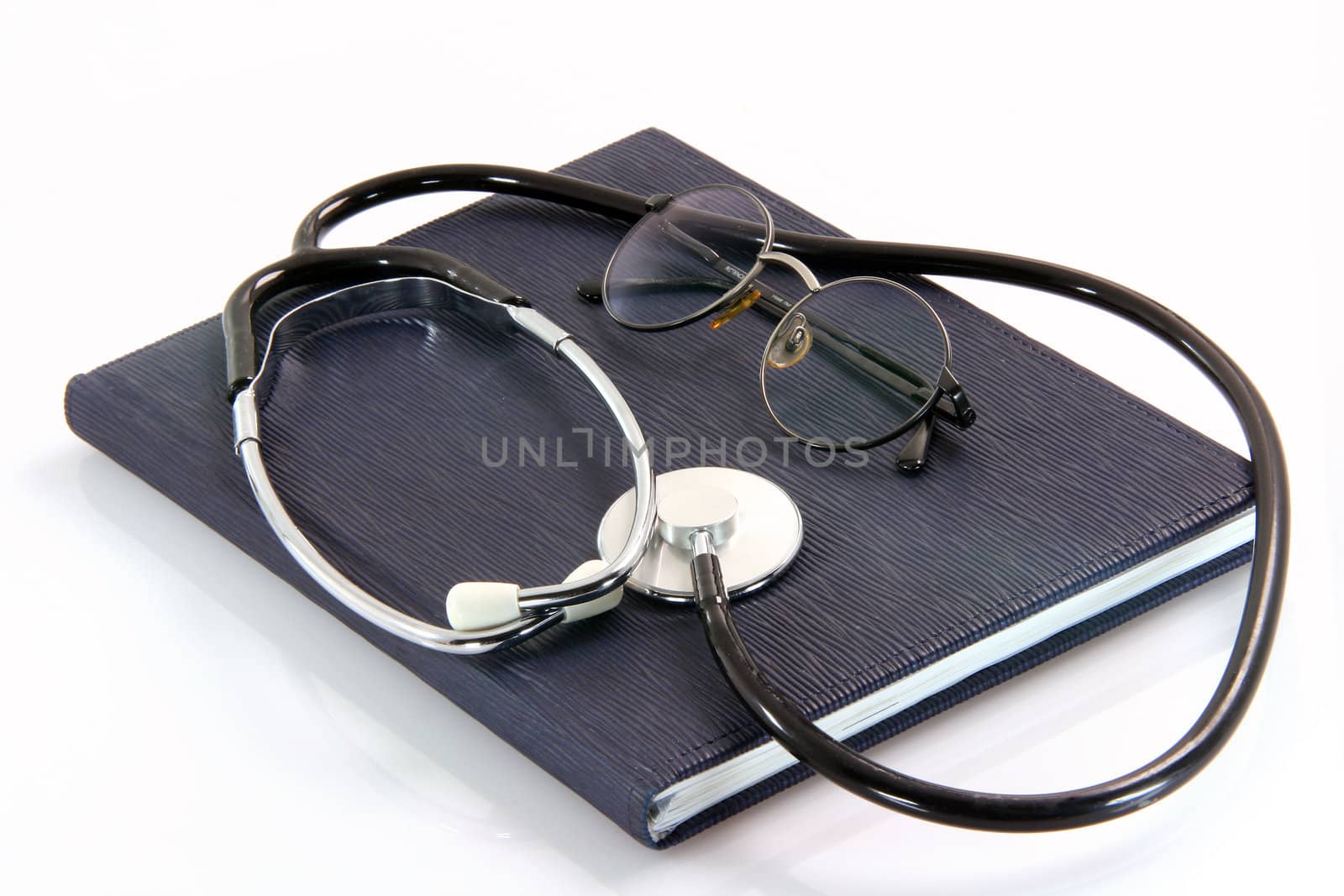 spectacles and phonendoscope on book health and medical objects isolated on white background