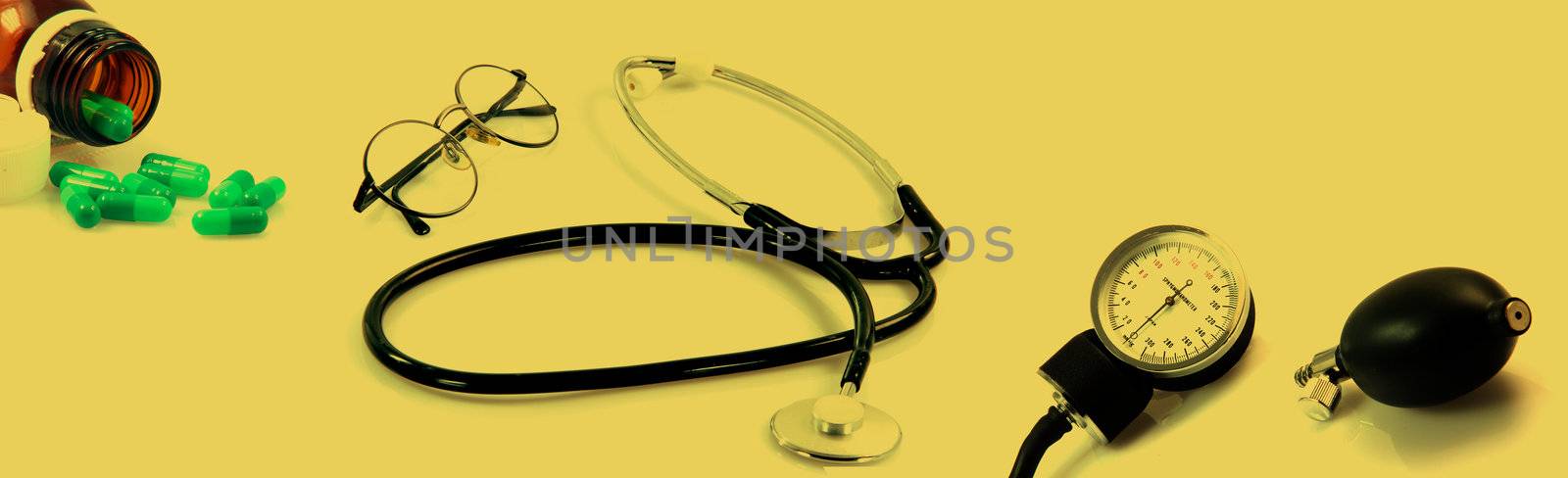 spectacles phonendoscope sphygmomanometer  and botle of pills in dark yellow tind health and medical objects this image is composed from 3 shuts with canon 400 xti