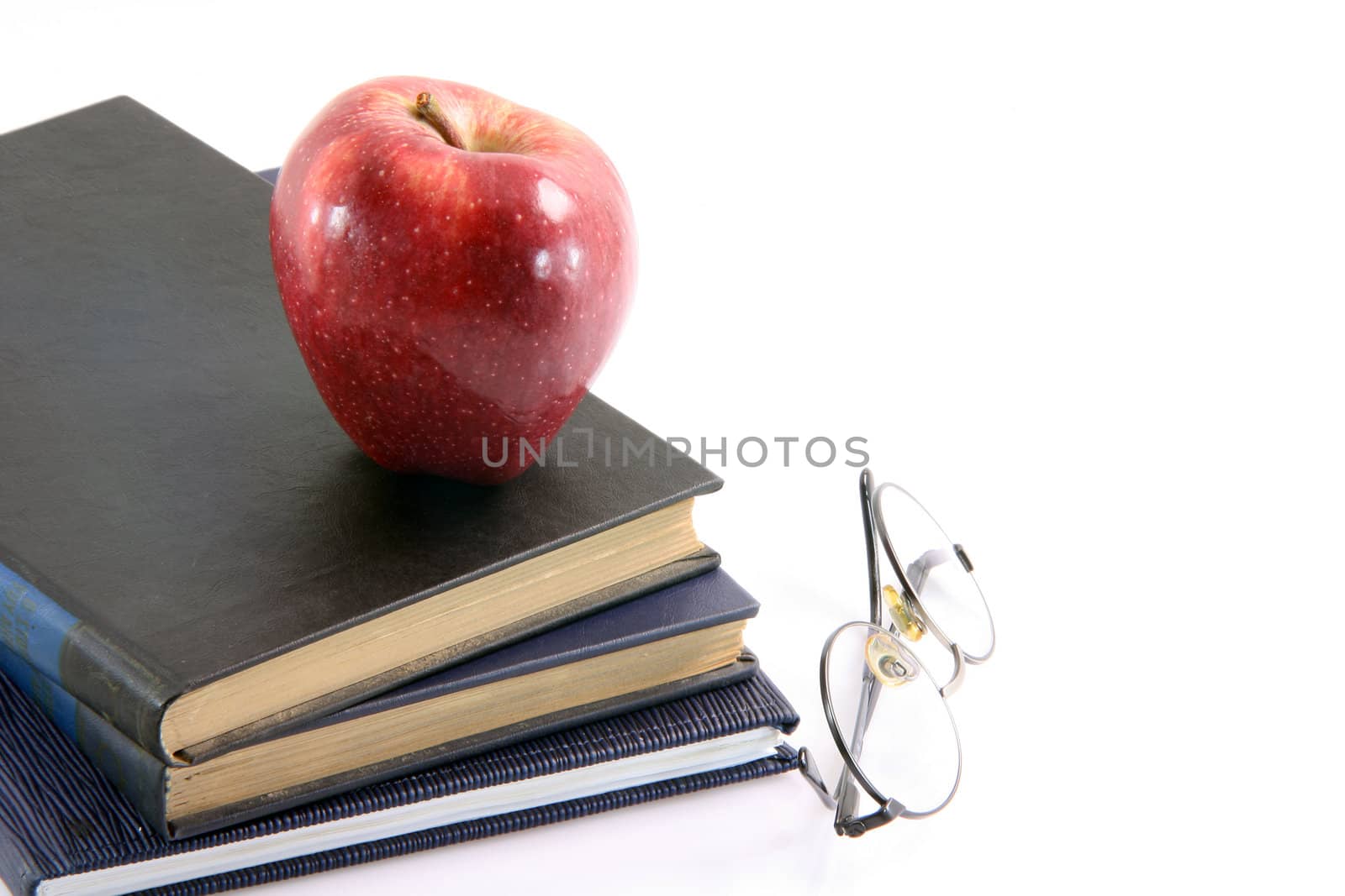 red apple on books with spectacles education diet healthy food and agriculture concepts isolated on white background