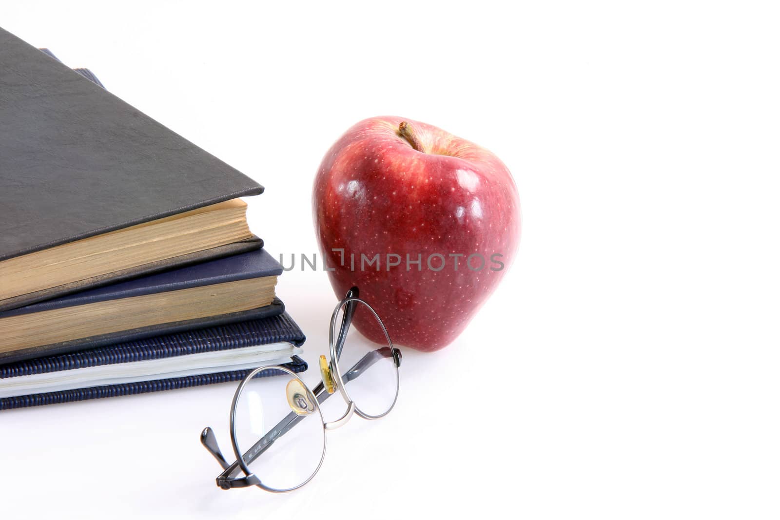 red apple and books with spectacles education diet healthy food and agriculture concepts isolated on white background